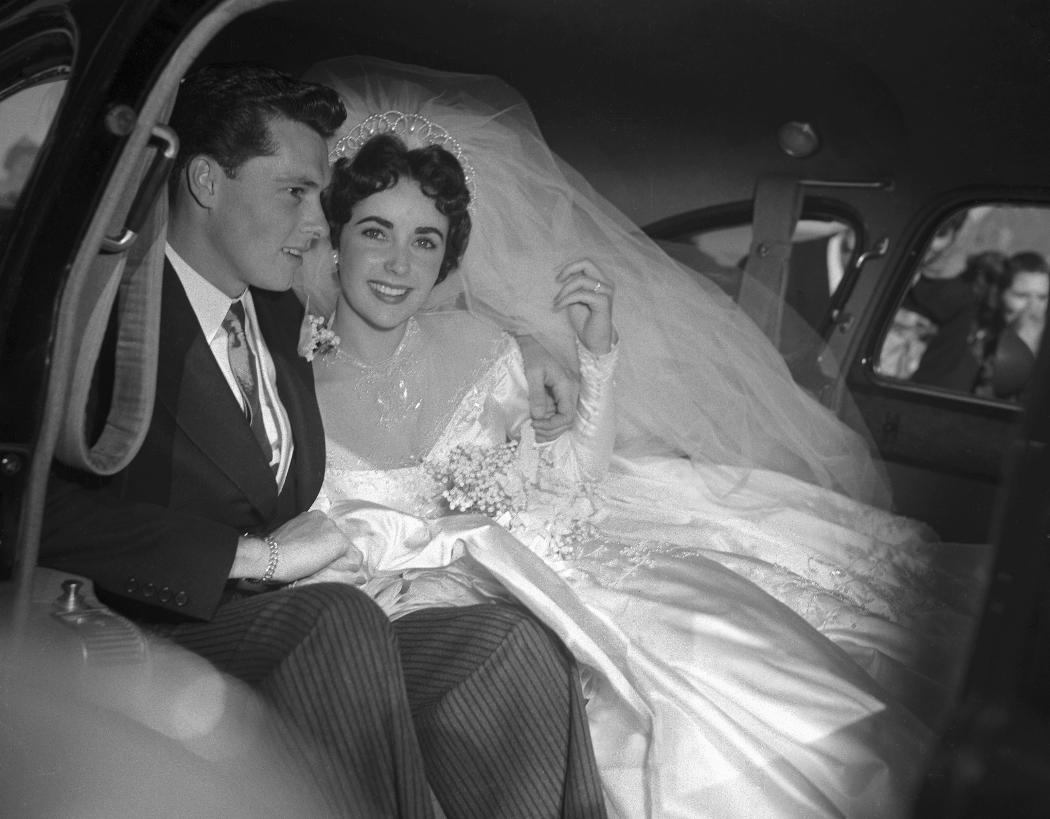Elizabeth Taylor and her groom, Conrad "Nickie" Hilton, Jr. in the limousine that will take them to their wedding reception at the Bel-Air Country Club, following their marriage at the Church of the Good Shepherd in Beverly Hills on May 6, 1950. | Source: Getty Images