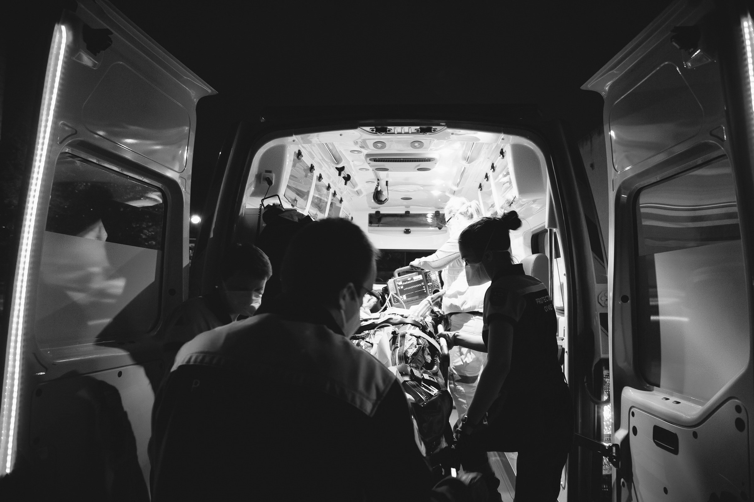 Paramedics lifting a gurney into an ambulance | Source: Unsplash