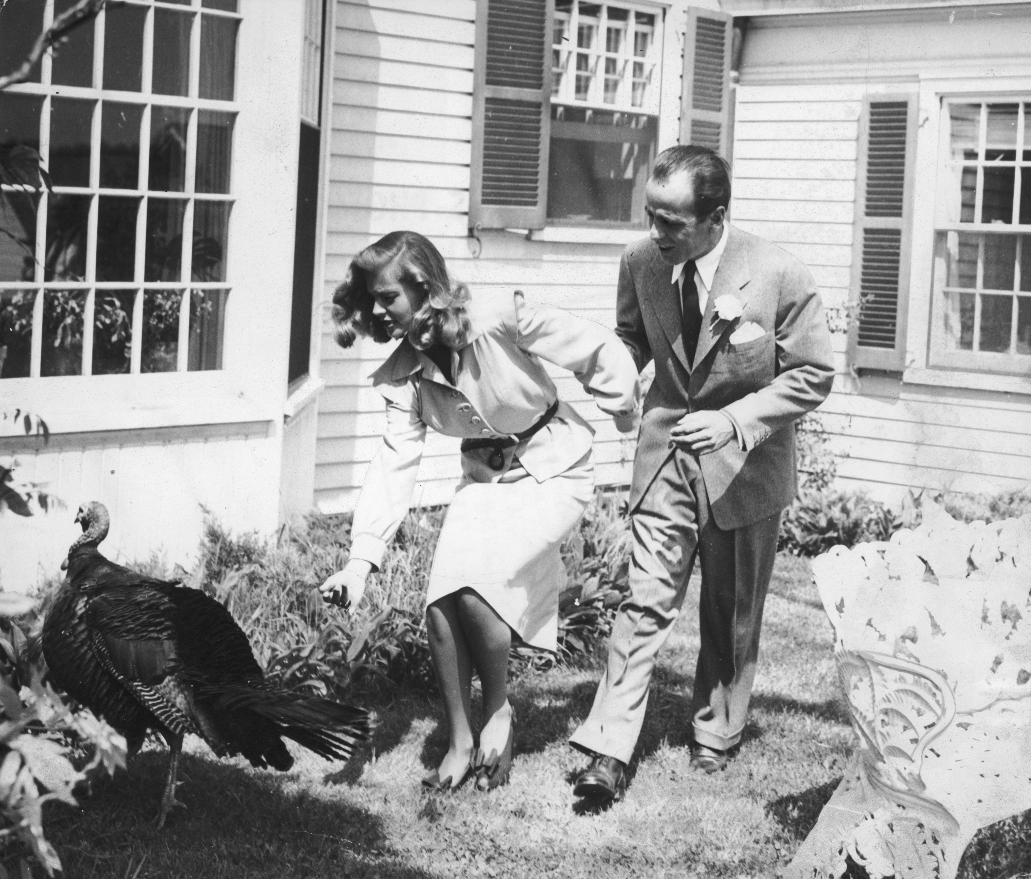 Lauren Bacall and Humphrey Bogart chase a turkey outside a house on the day of their wedding, at Malabar Farm in Mansfield, Ohio, on May 21, 1945. | Source: Source: Getty Images