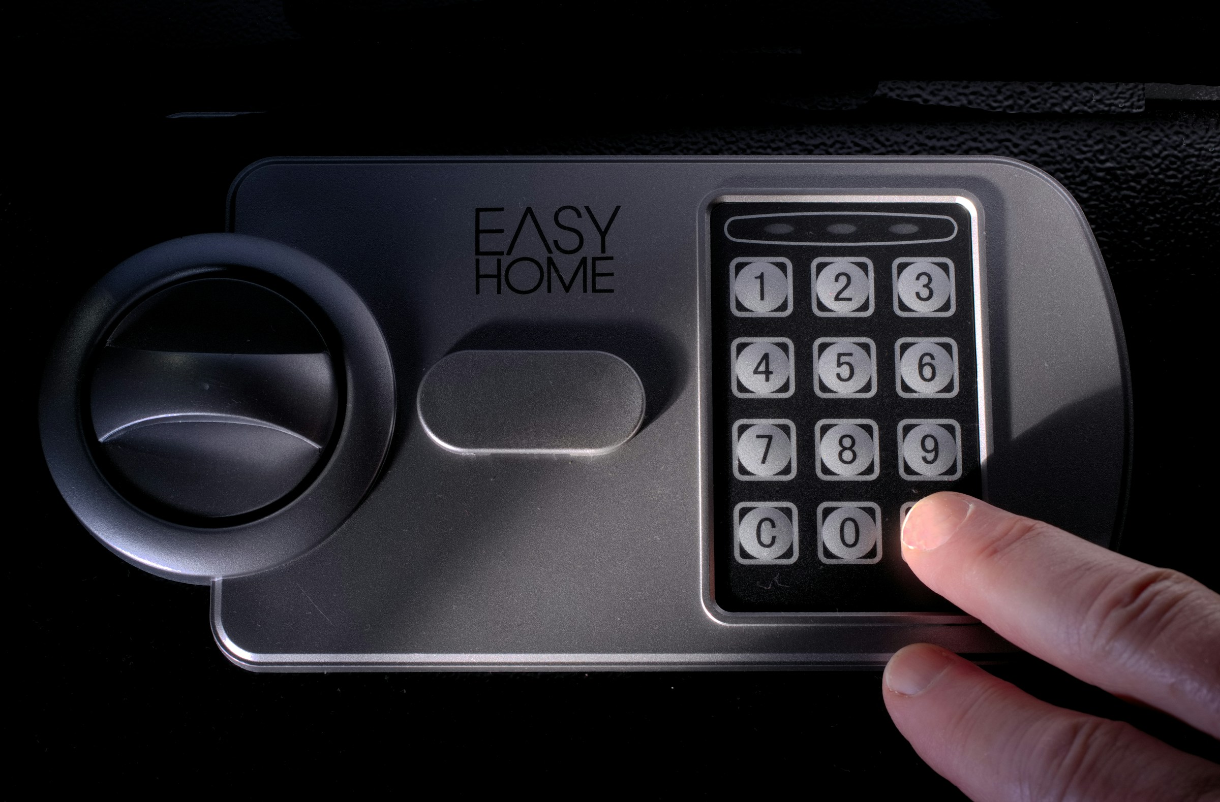 Someone entering a code on the numeric keypad of a safe | Source: Unsplash