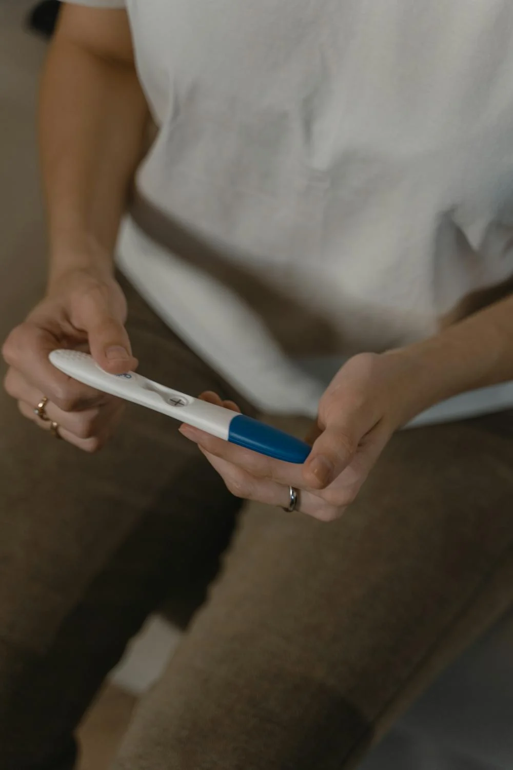 A nervous woman holding a pregnancy test | Source: Pexels