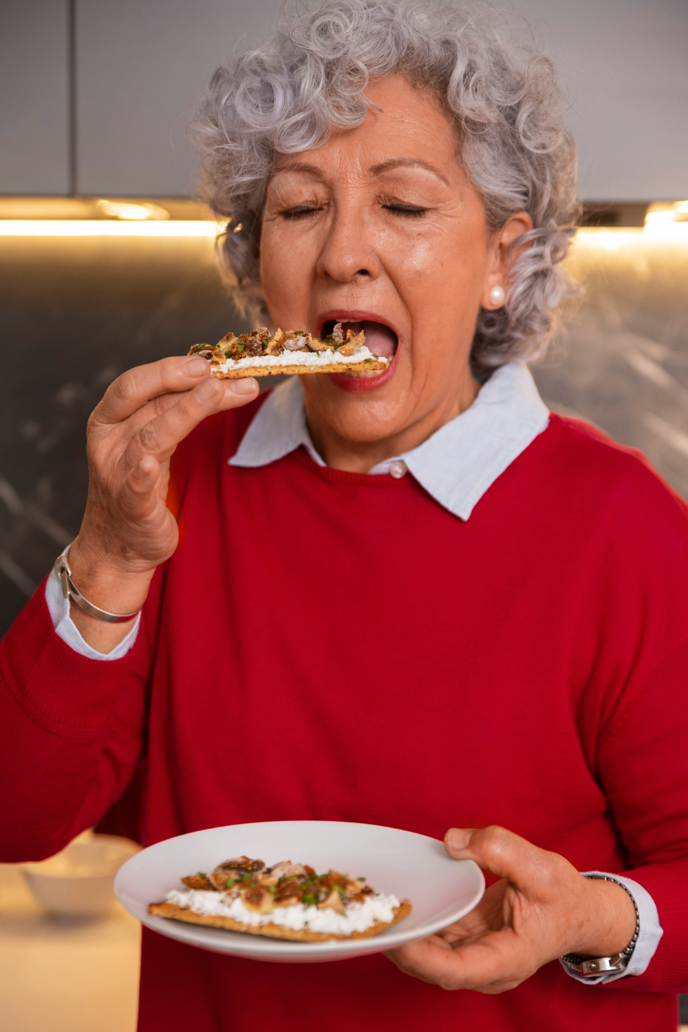 A senior woman eating food | Source: Freepik