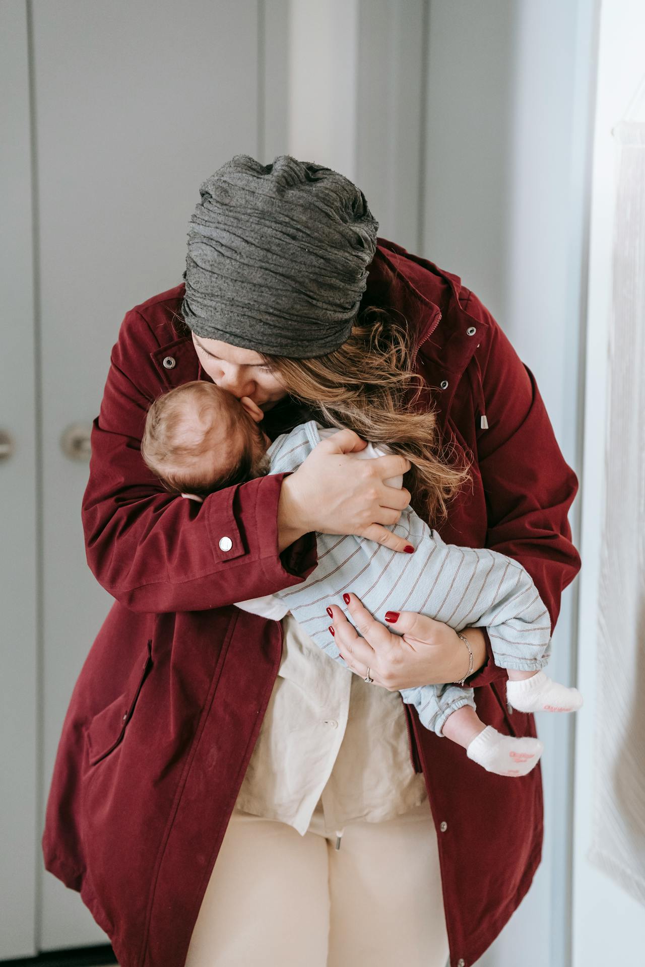A mother kissing her baby on the forehead | Source: Pexels