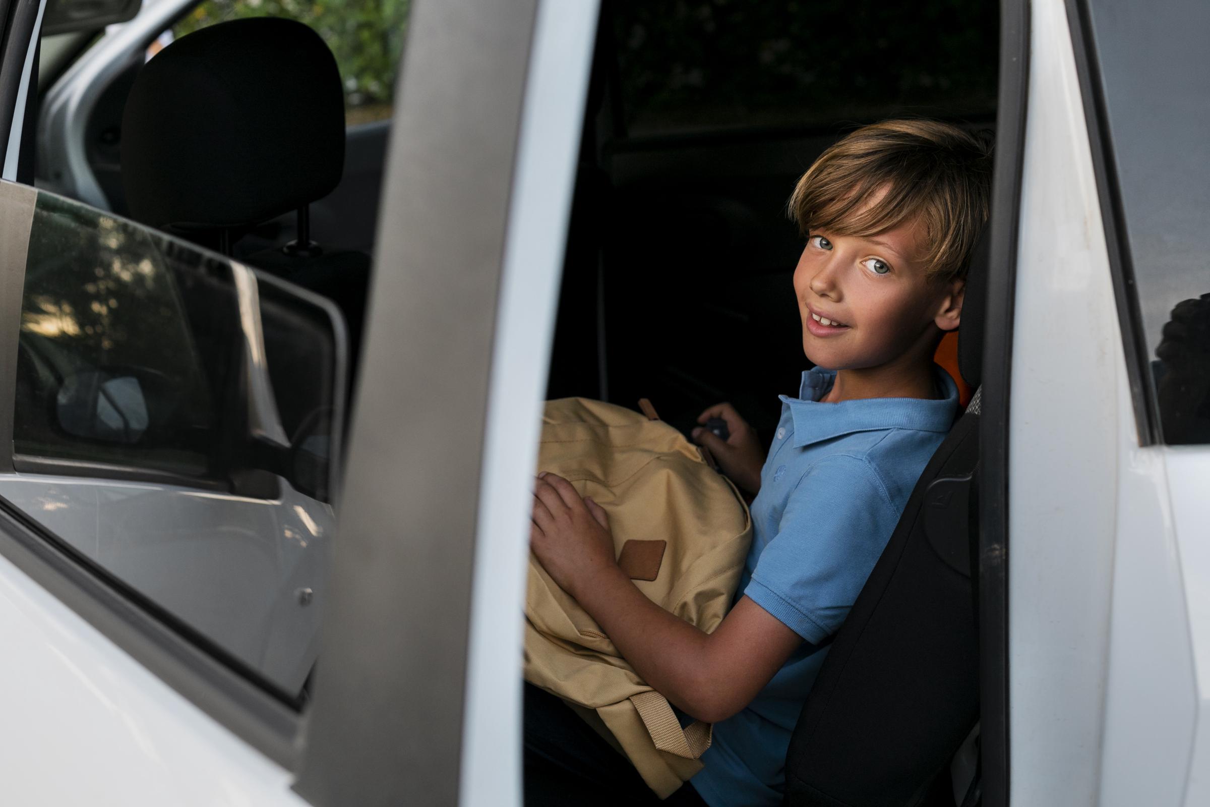 A boy smiling in a car | Source: Freepik