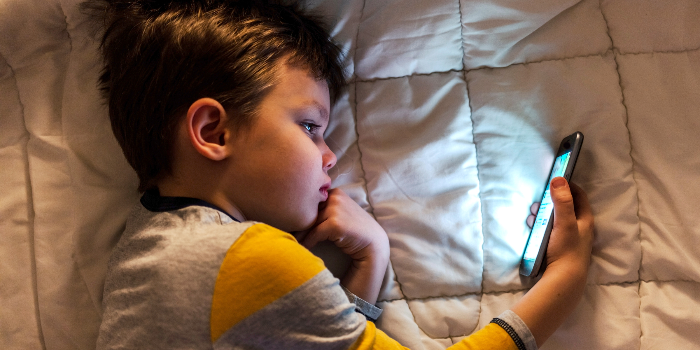 Little boy looking at a mobile phone | Source: Shutterstock