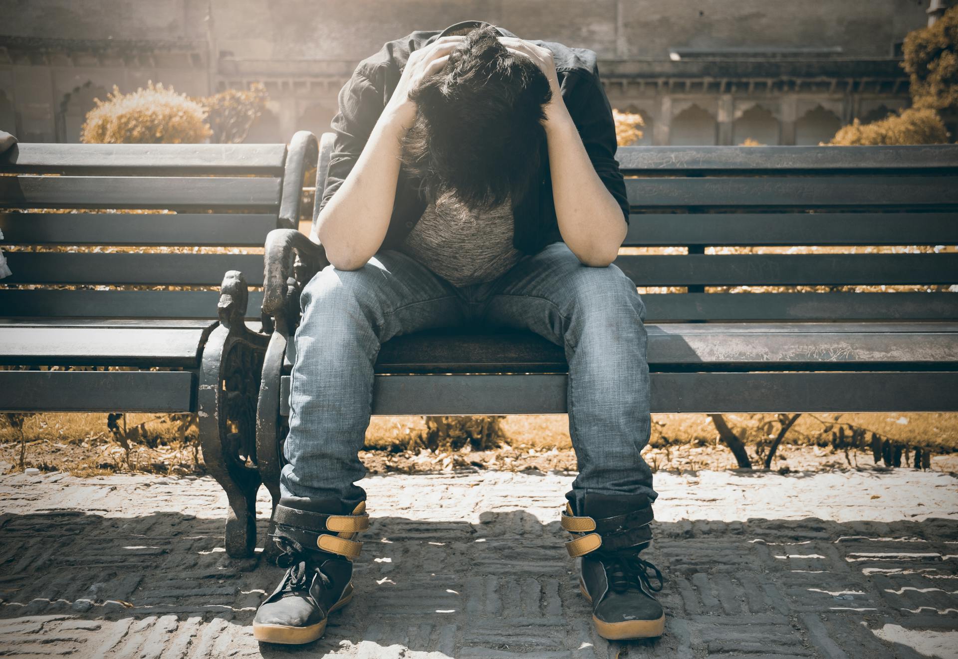 Un homme bouleversé assis sur un banc | Source : Pexels