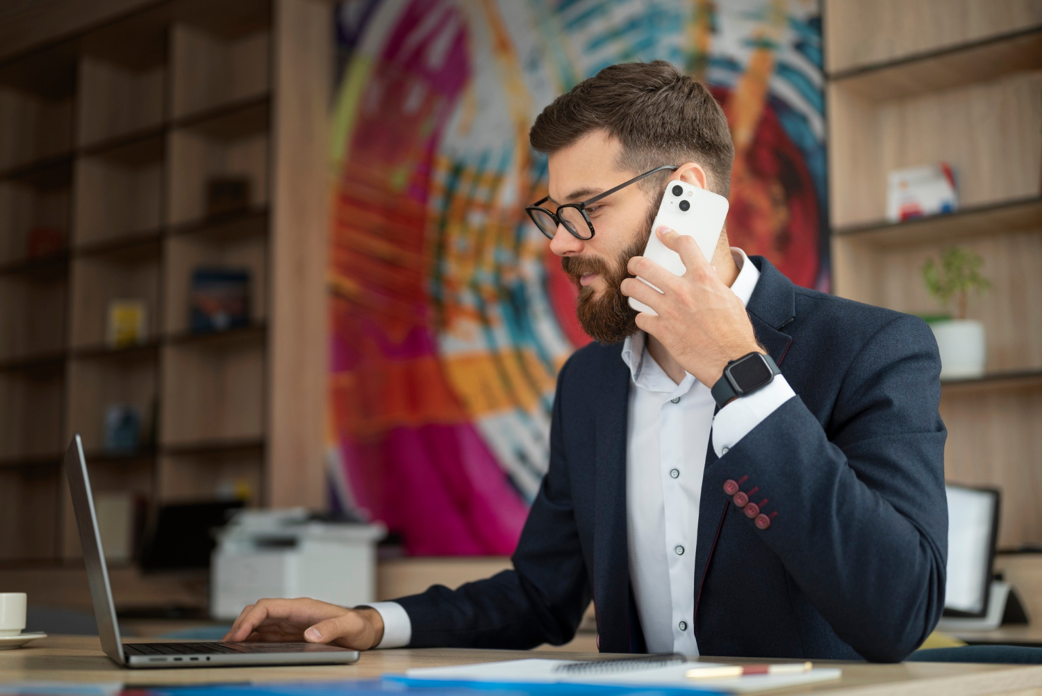 A man talking on the phone in his office | Source: Freepik