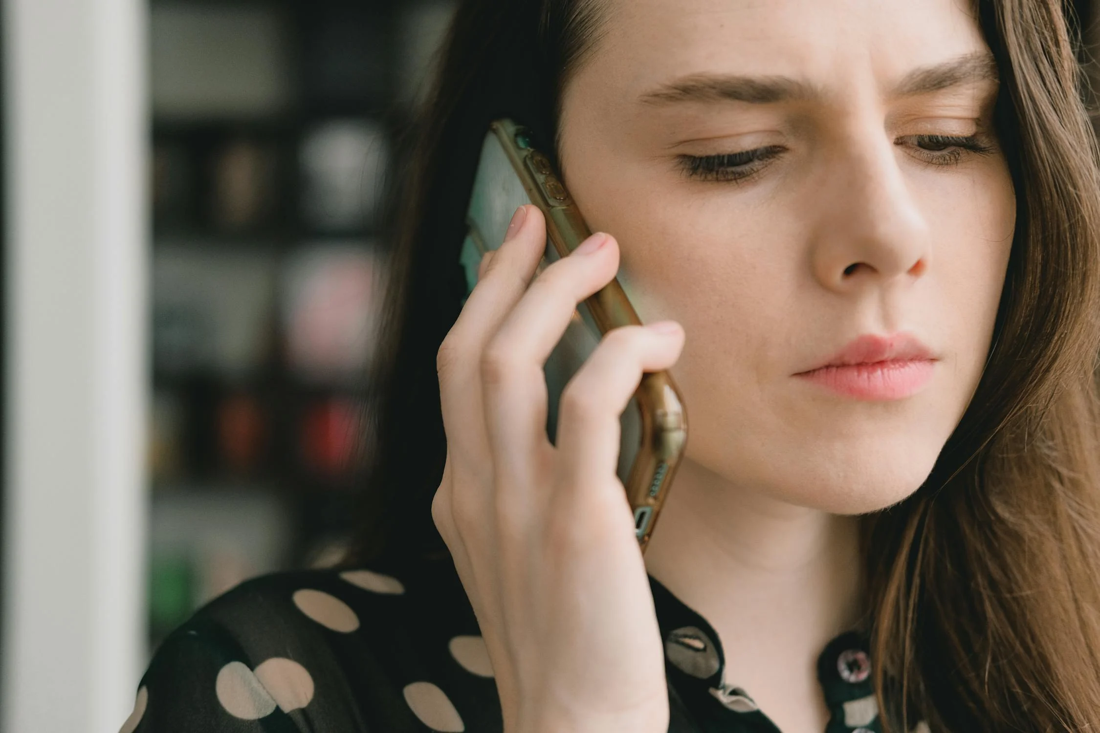 Uma mulher séria falando ao telefone | Fonte: Pexels