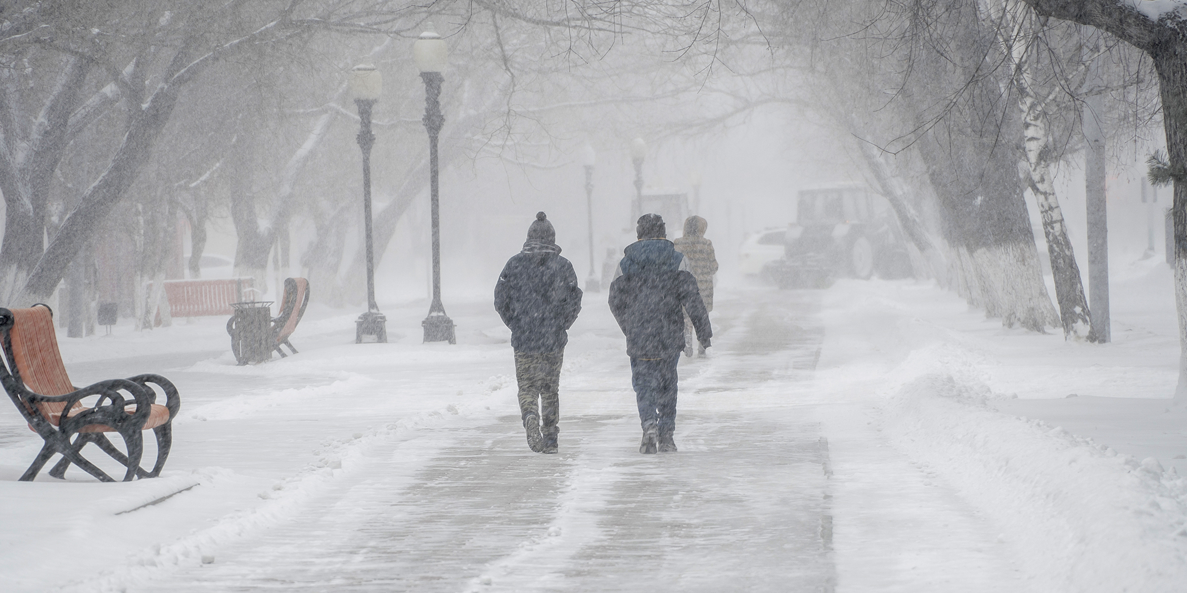 Two people working in the snow | Source: Shutterstock