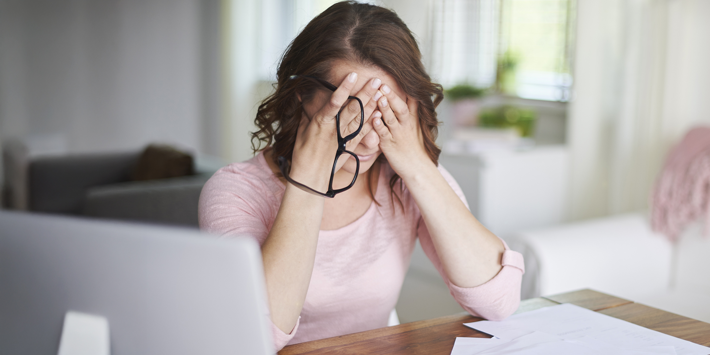A worried woman sitting with her head in her hands | Source: Shutterstock