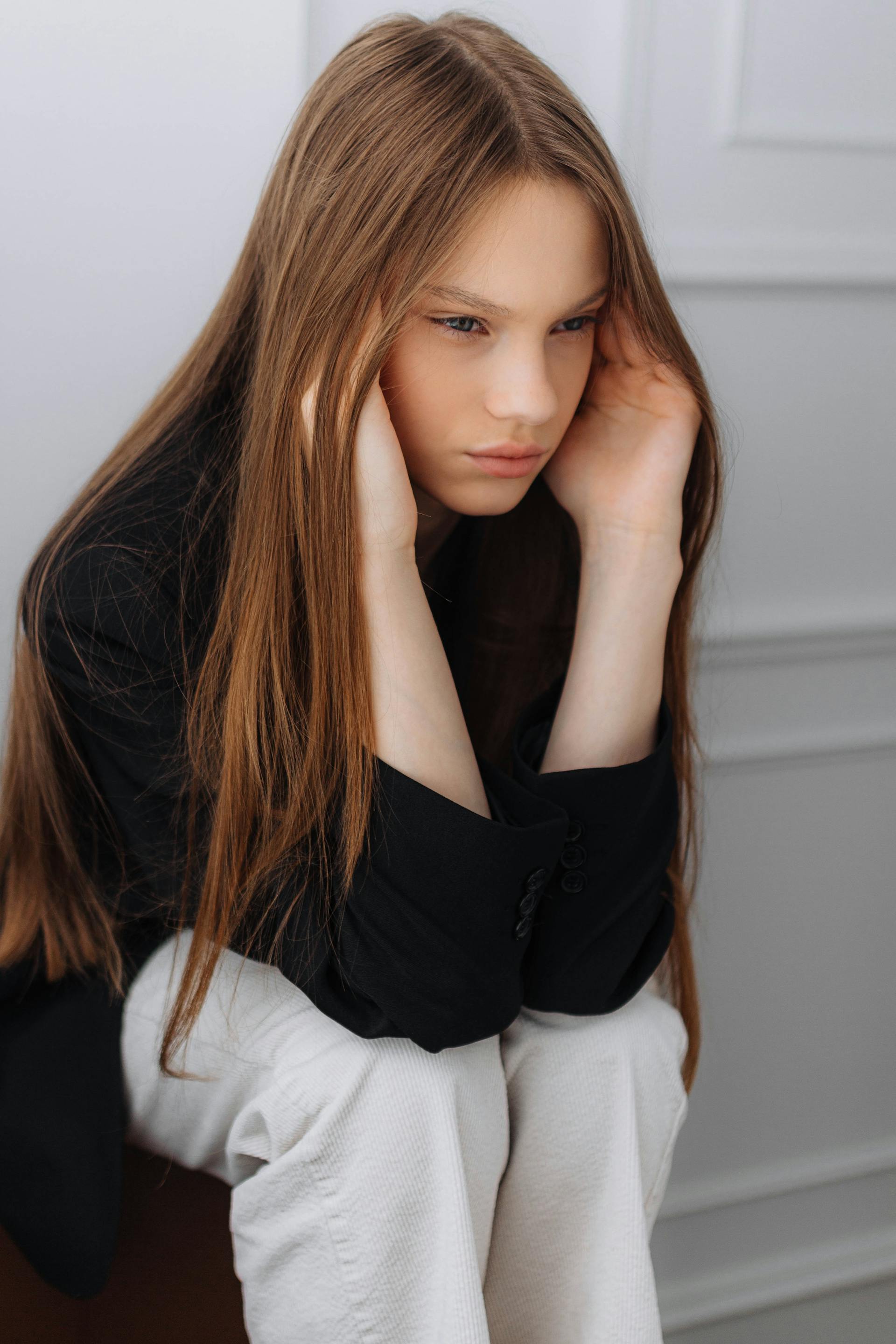 An upset teenage girl sitting down | Source: Pexels