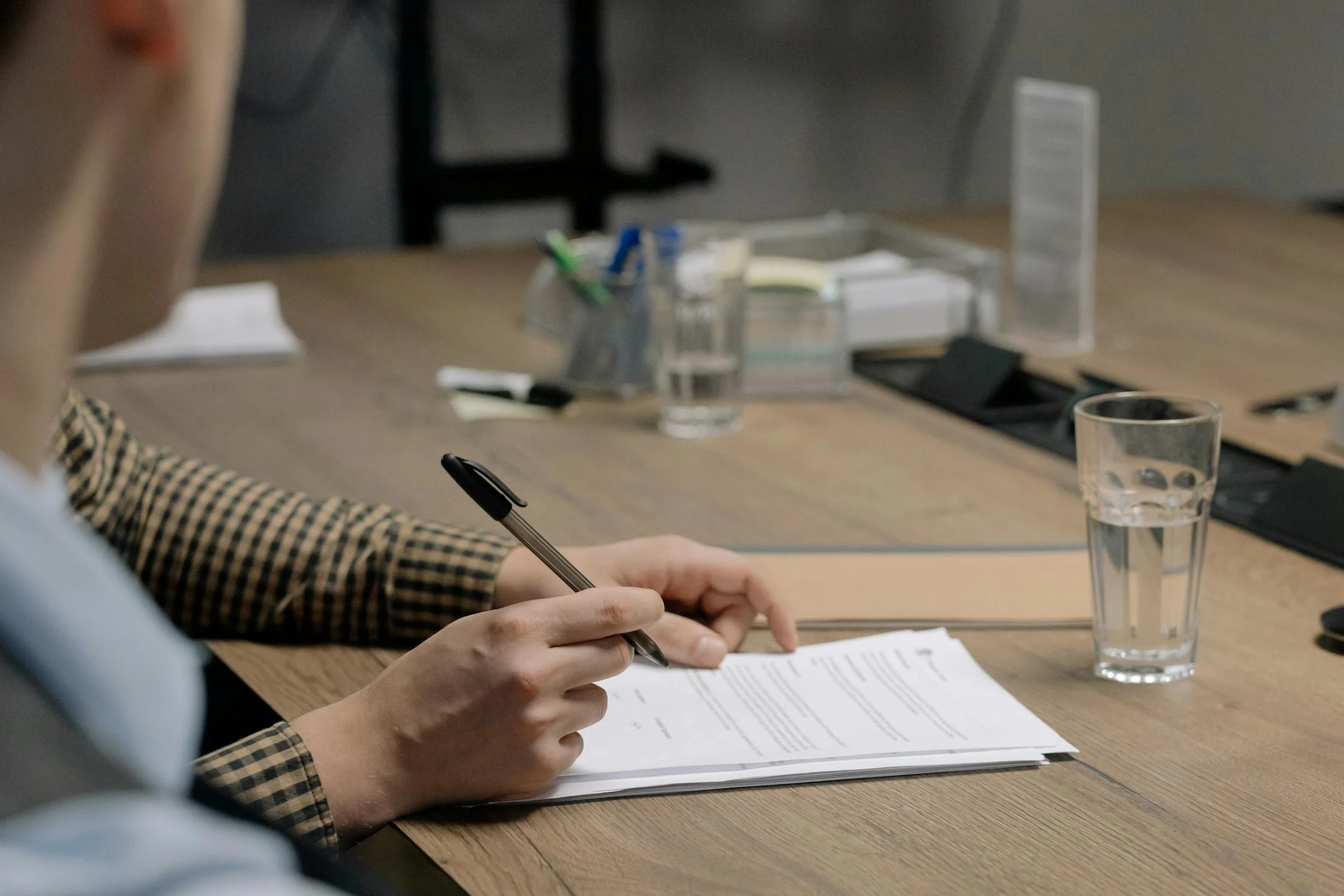 A woman signing documents | Source: Pexels