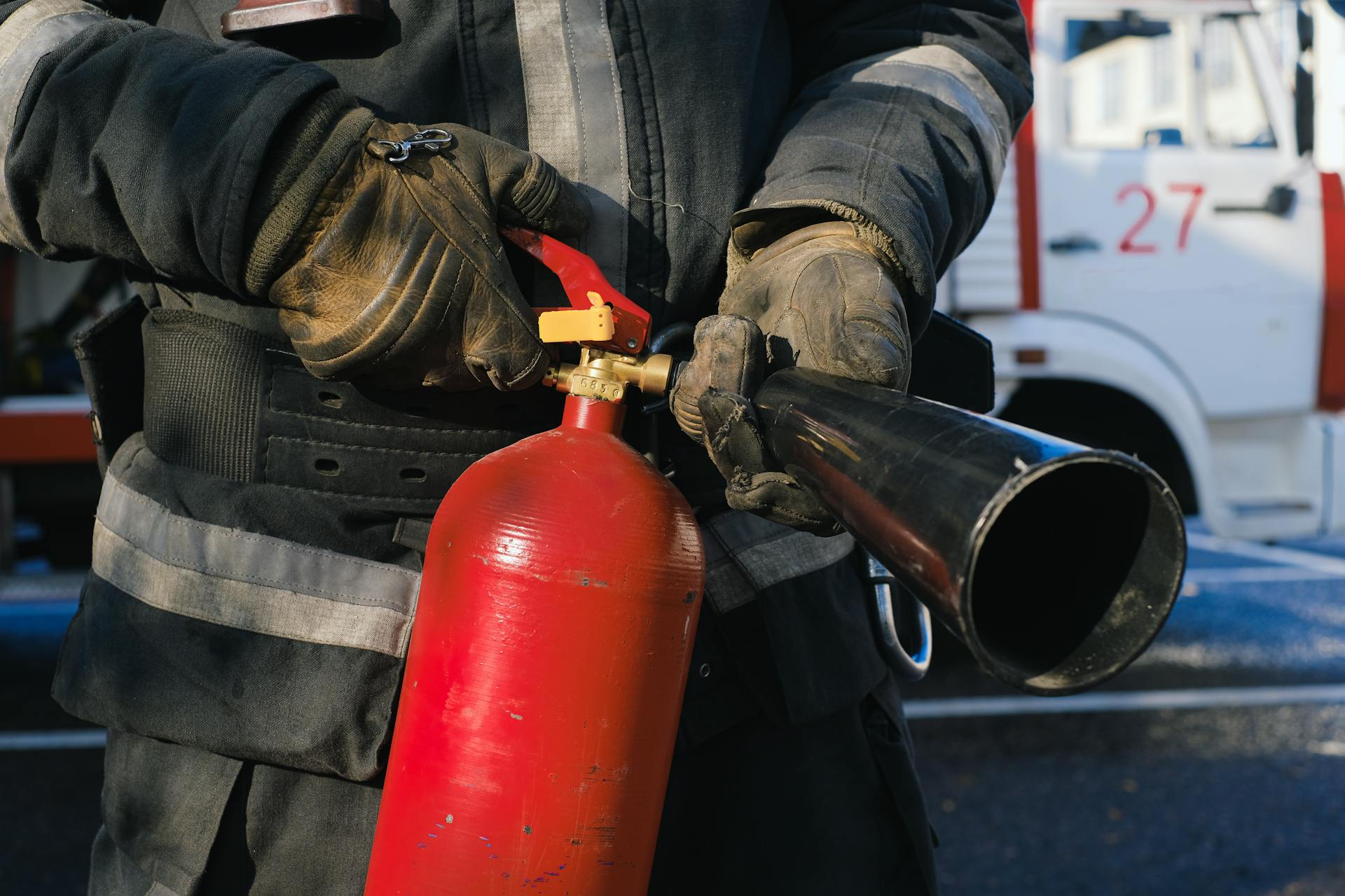 A firefighter holding a fire extinguisher | Source: Pexels