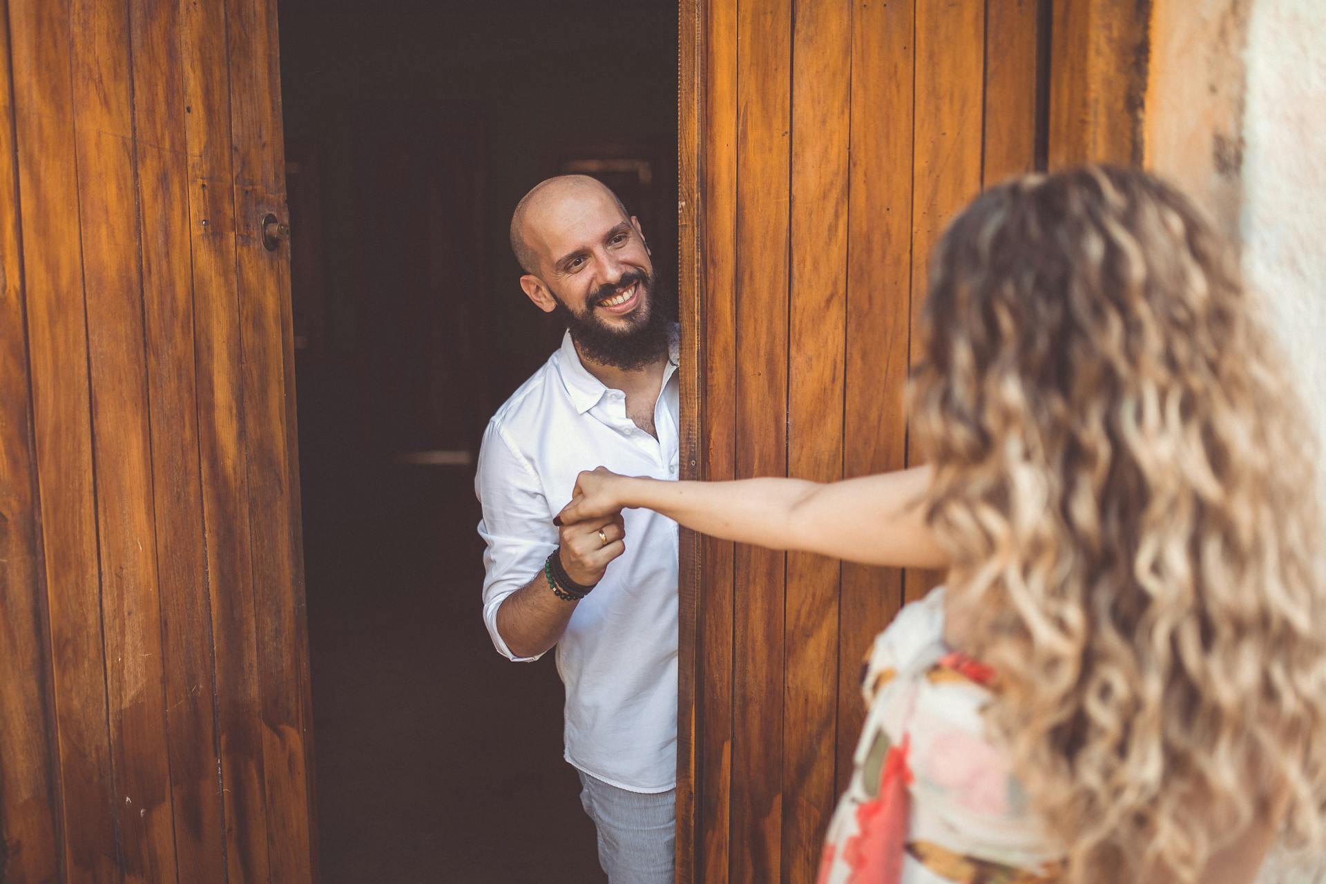 A happy man welcoming a woman into his house | Source: Pexels