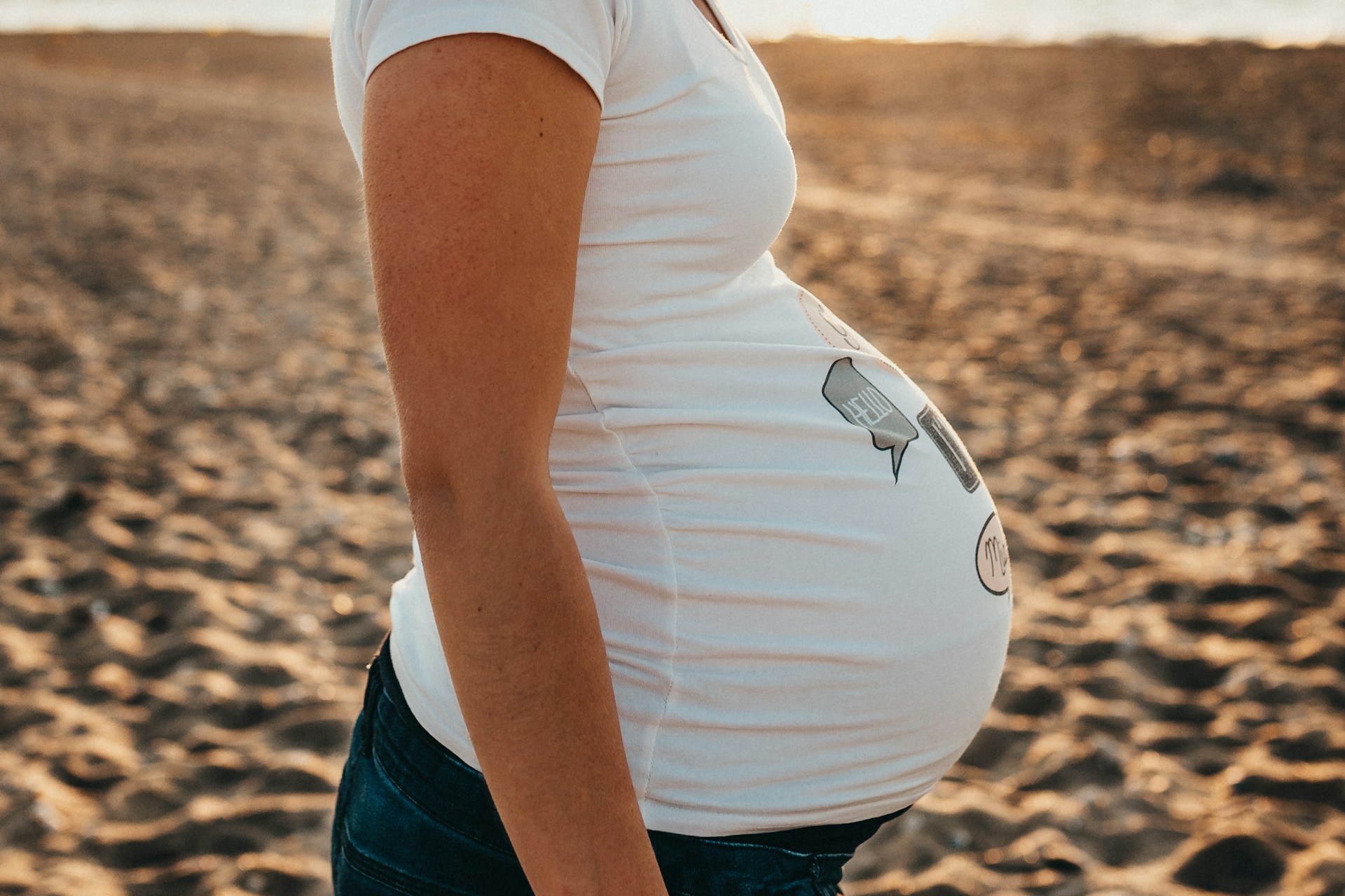 A pregnant woman standing on the beach | Source: Unsplash