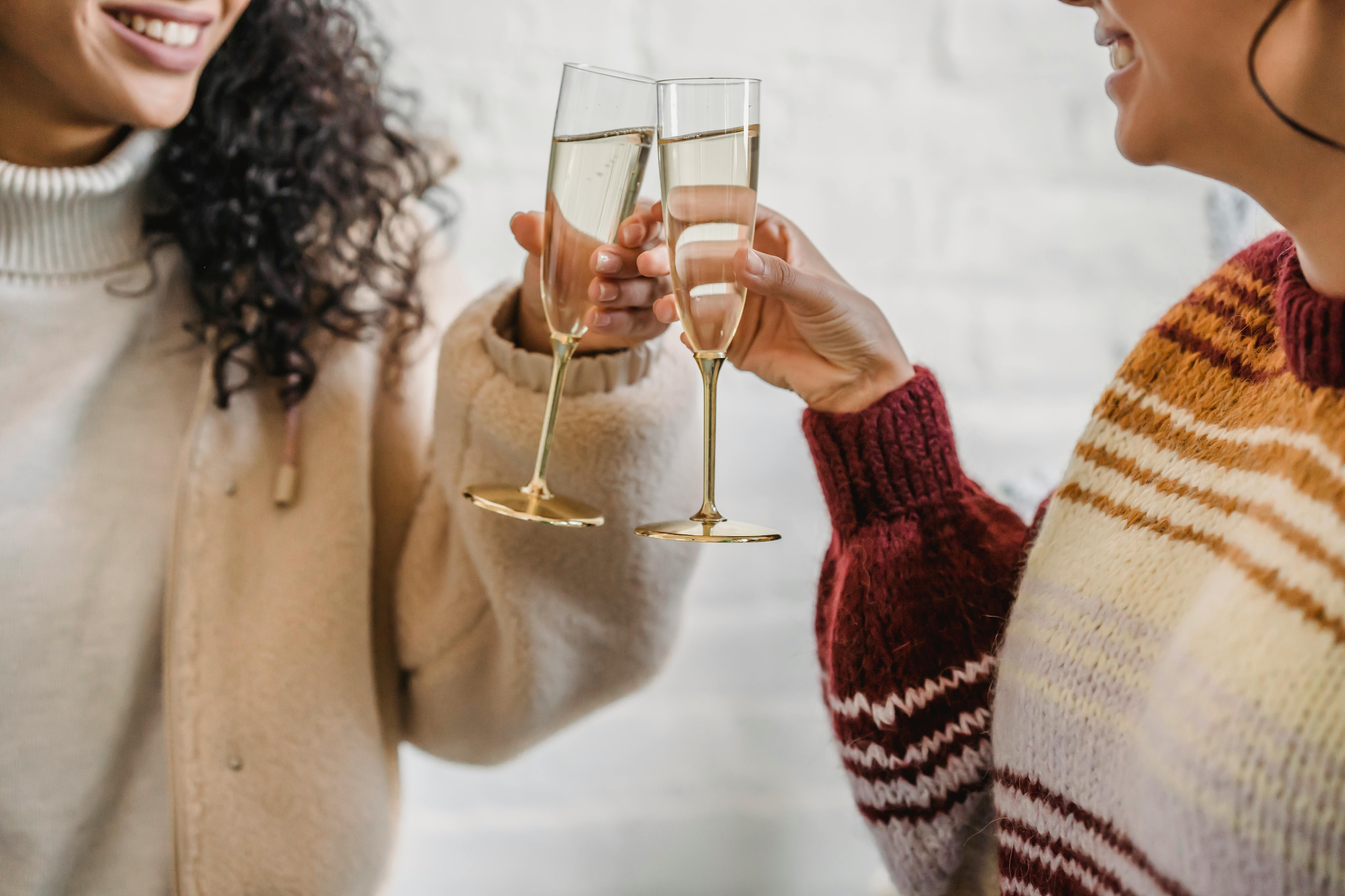 Two women clinking glasses | Source: Pexels