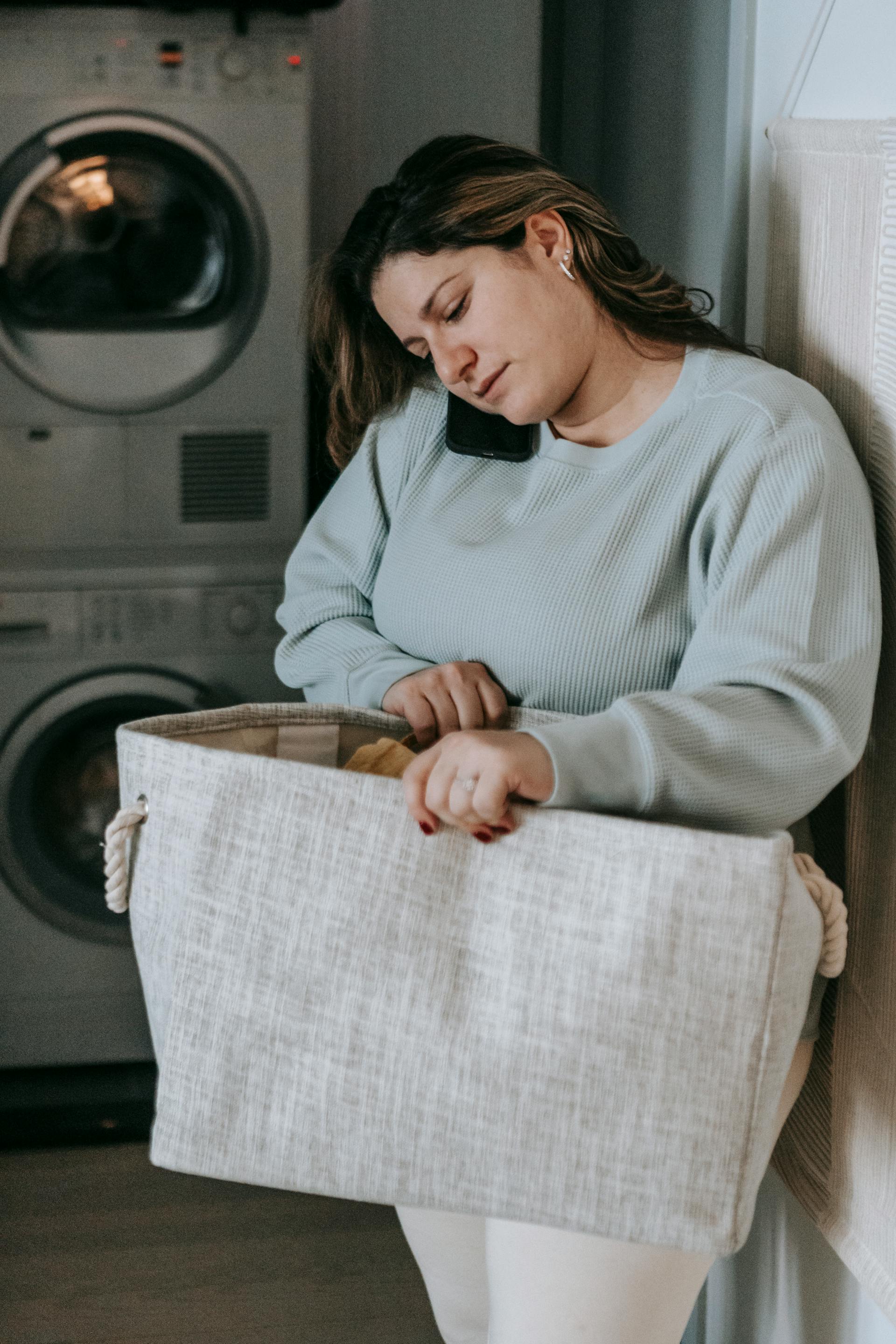A woman holding a laundry hamper | Source: Pexels