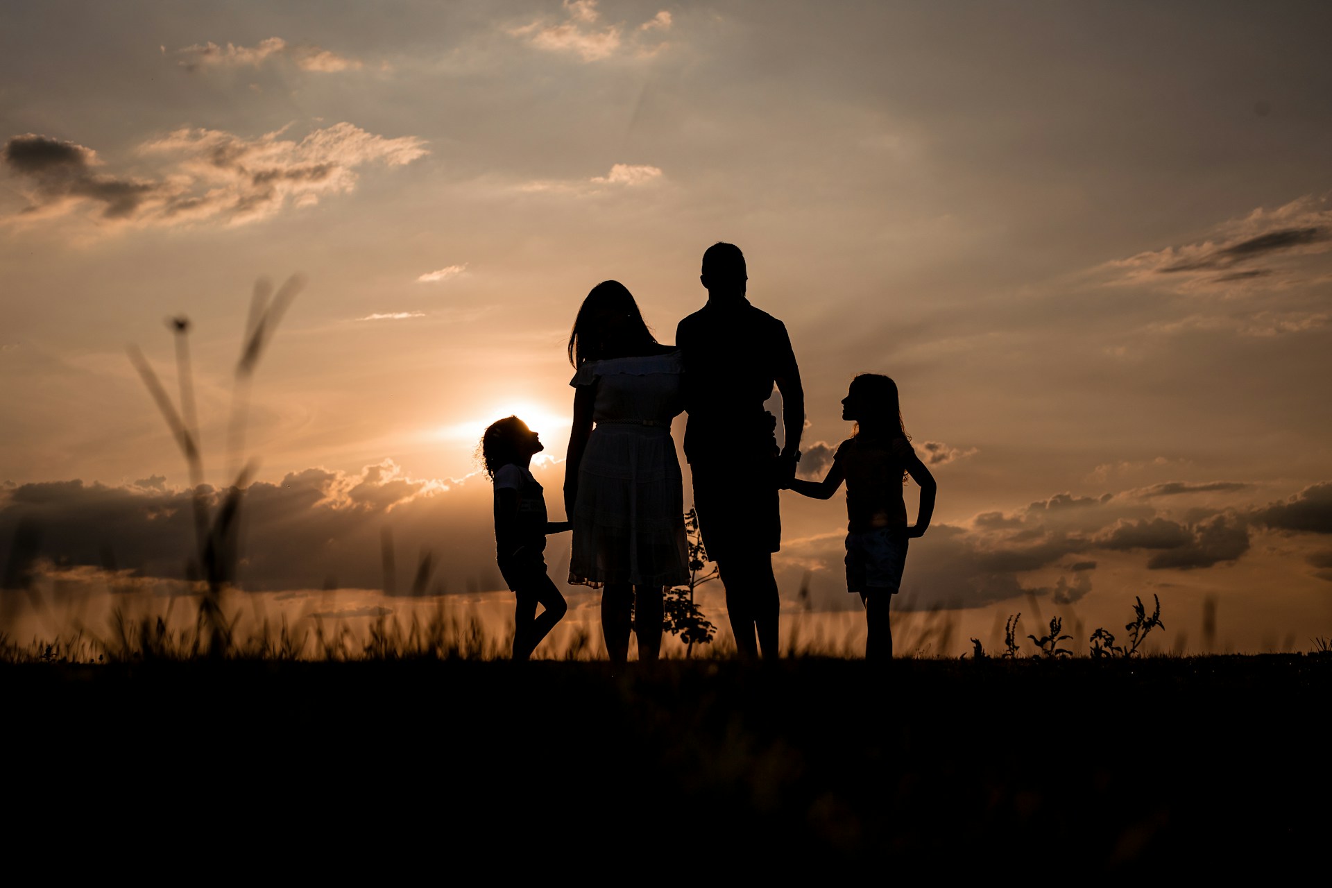 Silhouette of a couple with their children | Source: Unsplash