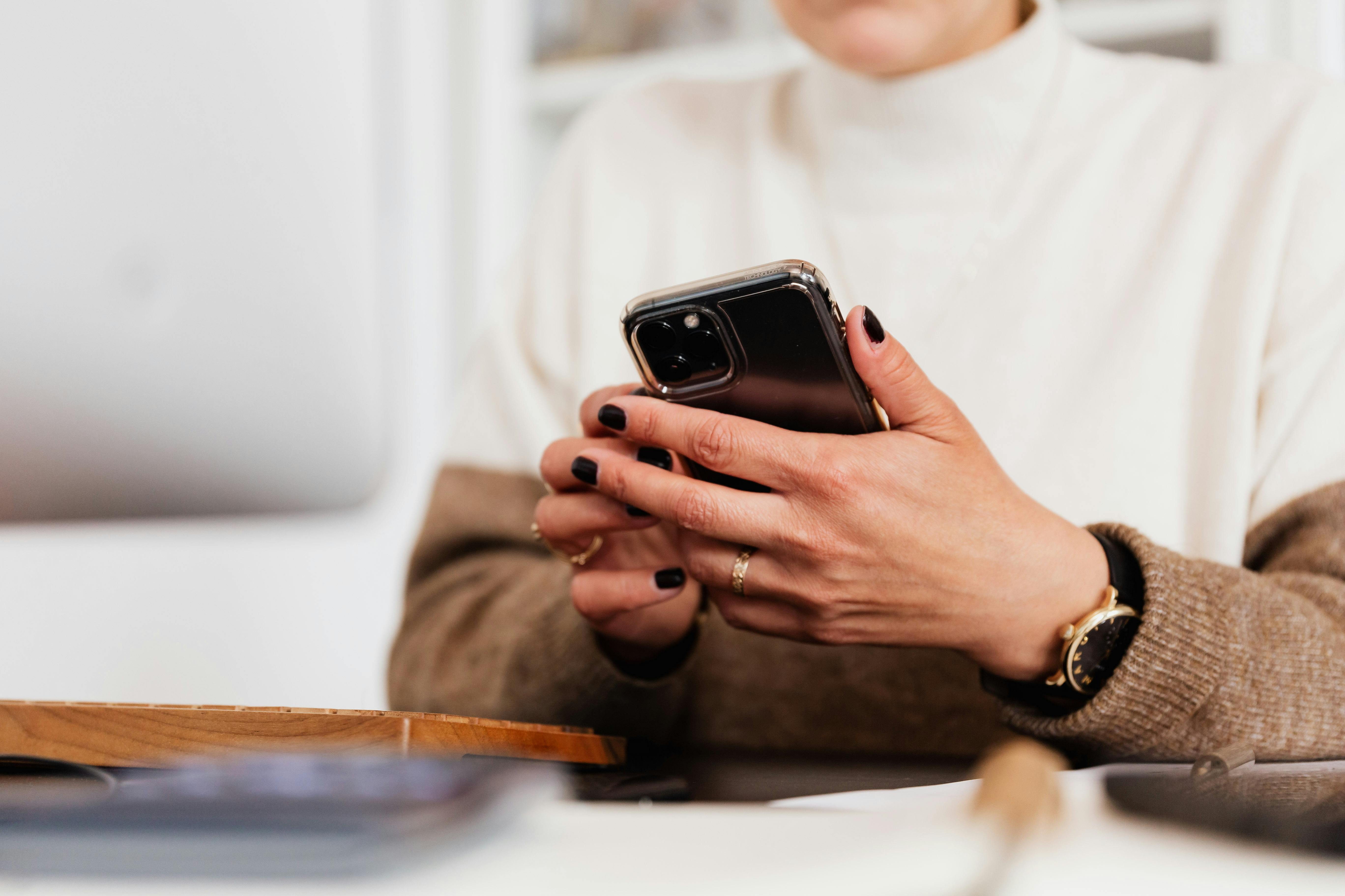 Woman holding her smartphone | Source: Pexels