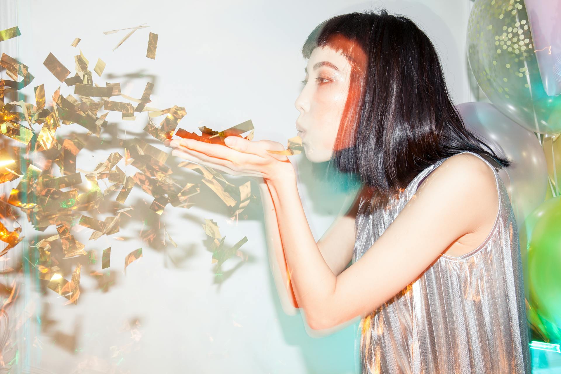 A woman blowing confetti into the air | Source: Pexels