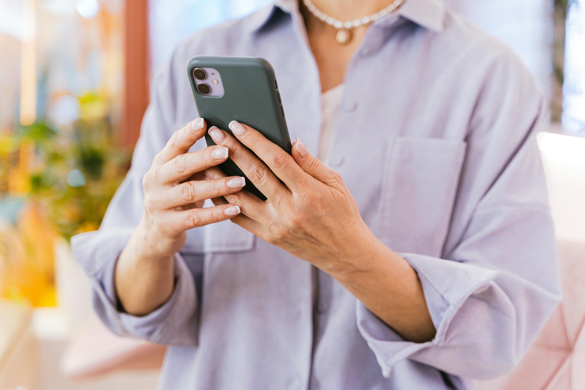 A woman holding her phone | Source: Pexels