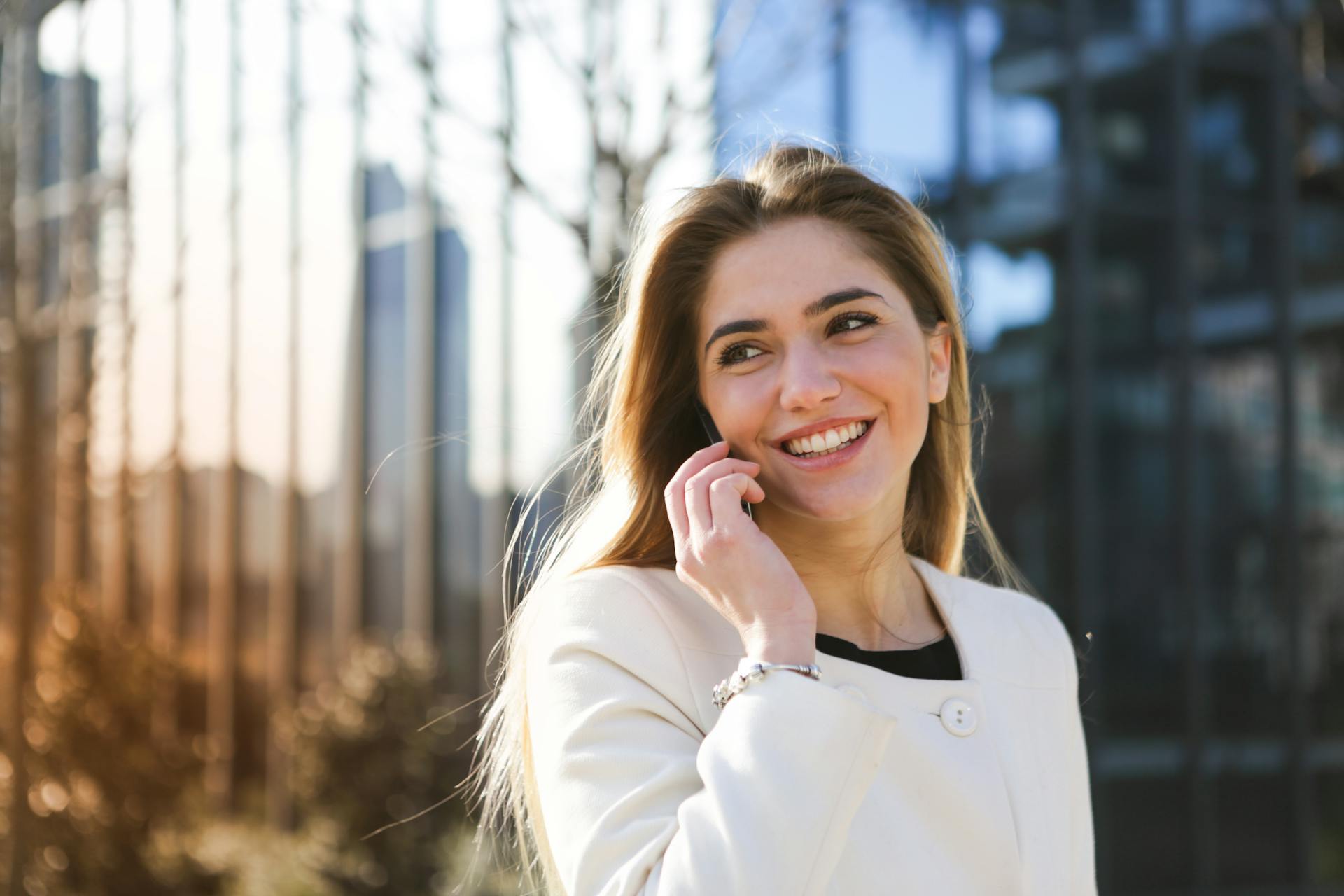 A smiling woman talking on the phone | Source: Pexels