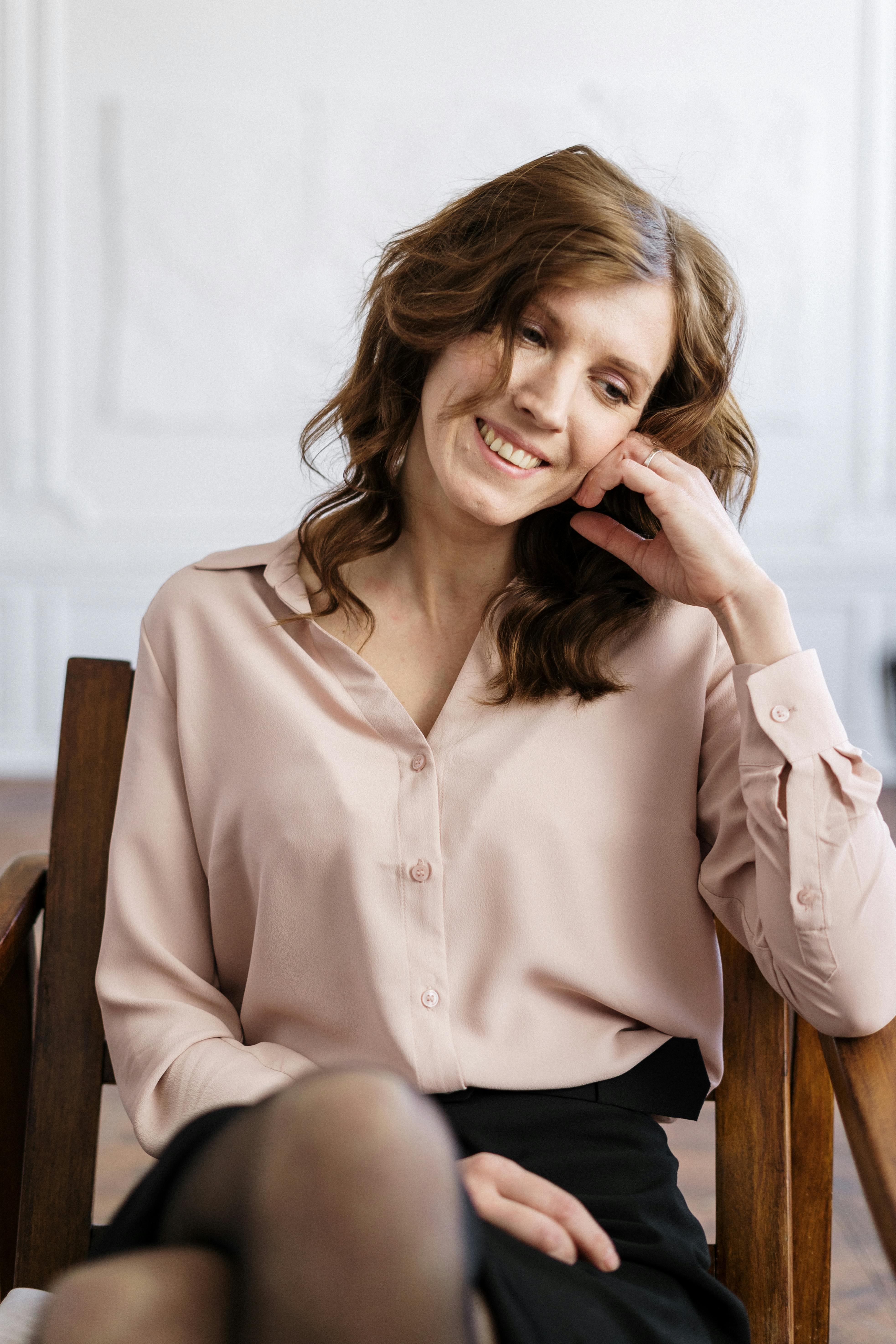 A woman smiling while talking to someone | Source: Pexels