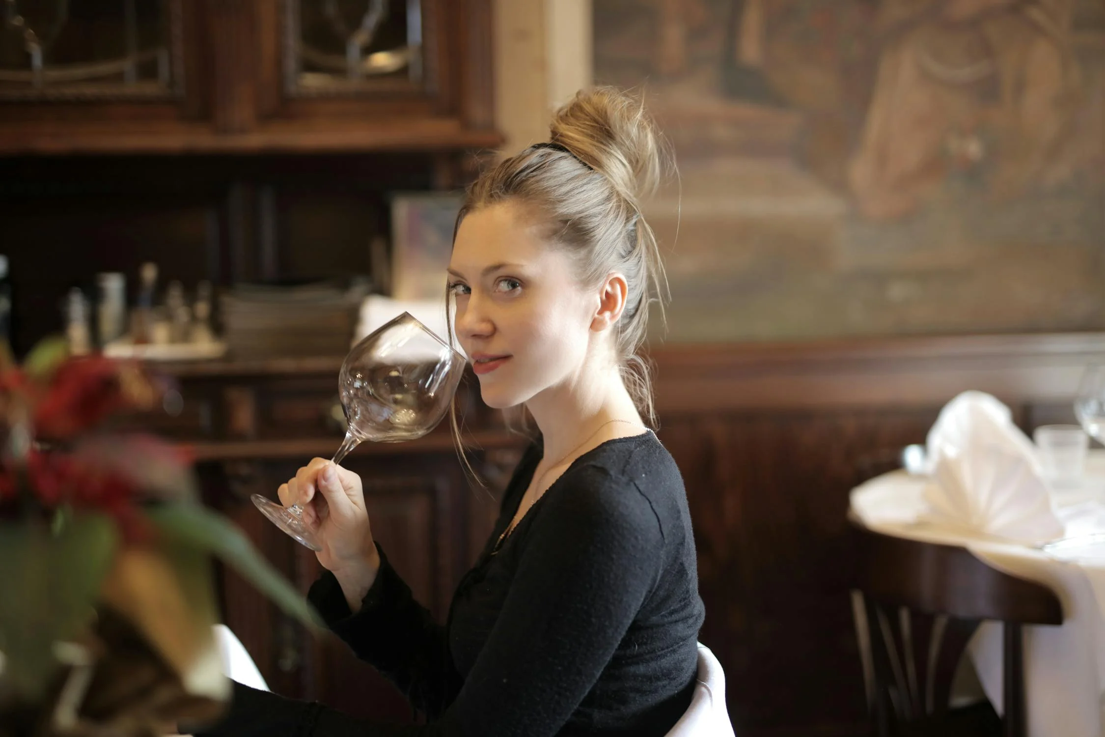 A smiling woman looking to her side in a restaurant | Source: Pexels