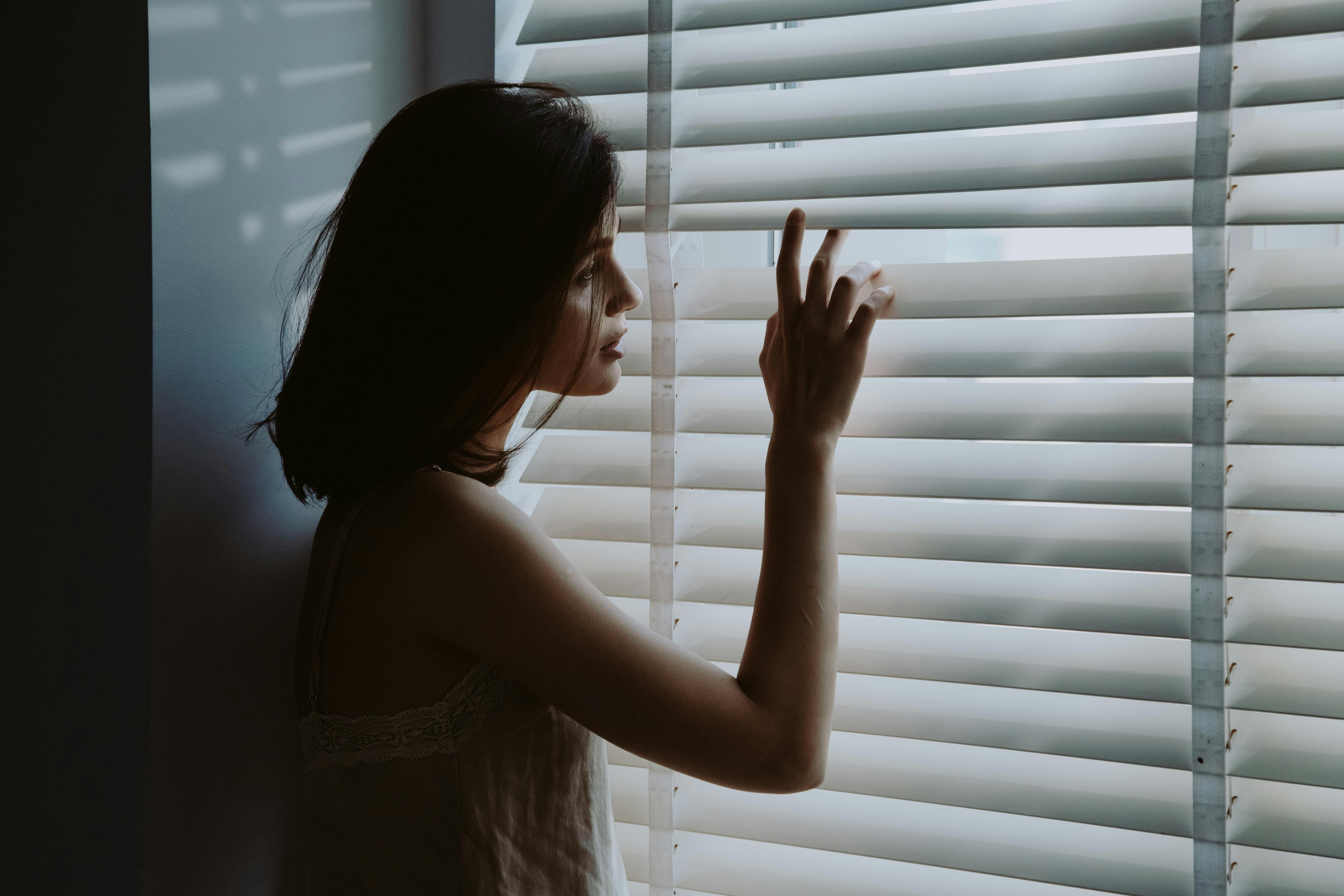 A woman looking through the window | Source: Pexels