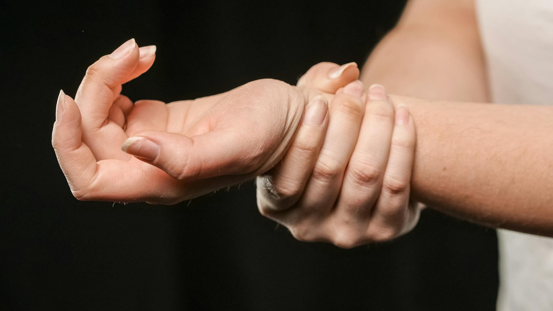 Close-up shot of a woman holding her left wrist | Source: Pexels
