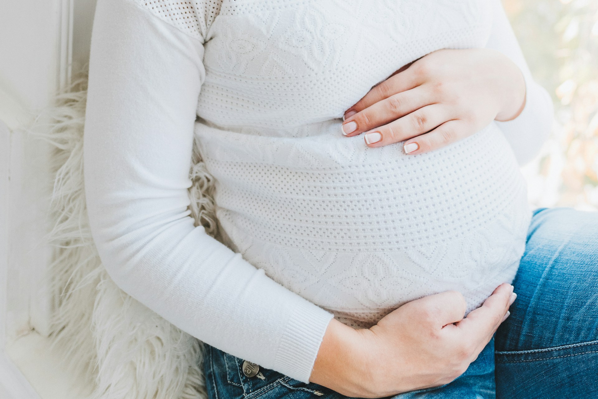 A pregnant woman holding her baby bump | Source: Unsplash