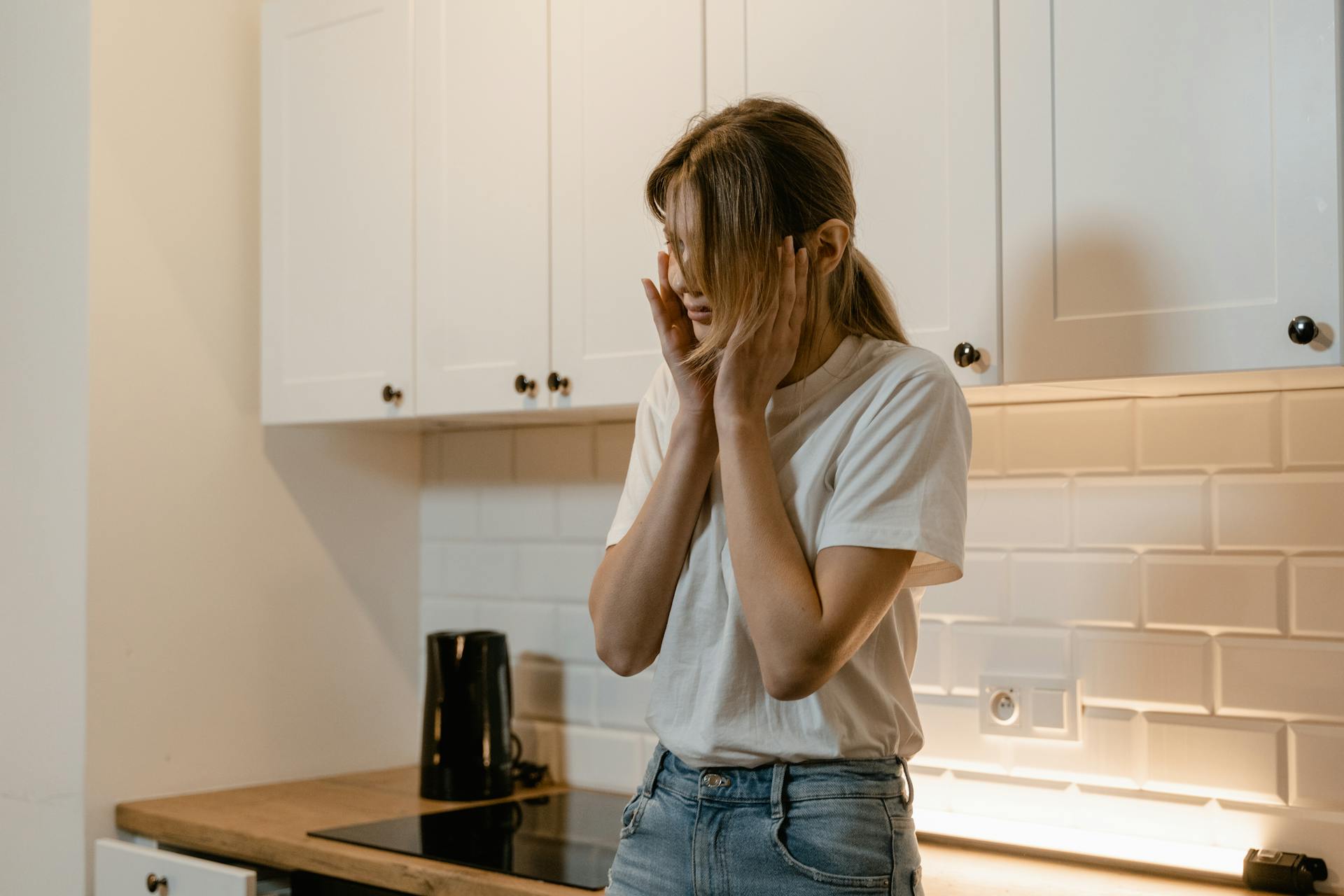 An anxious-looking woman in a kitchen | Source: Pexels