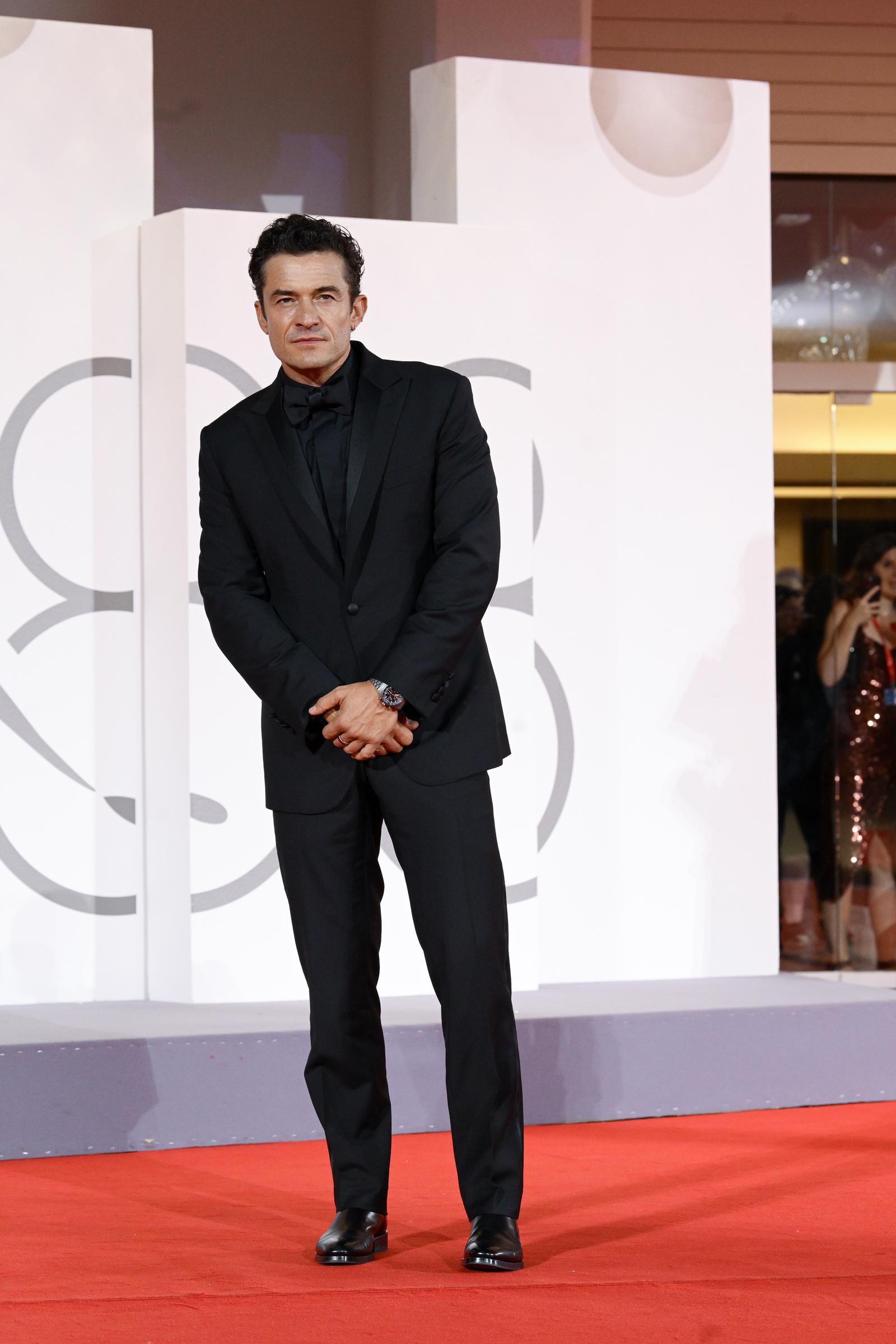 Orlando Bloom cuts a classic figure in a black tuxedo as he poses on the red carpet during the Venice Film Festival. | Source: Getty Images