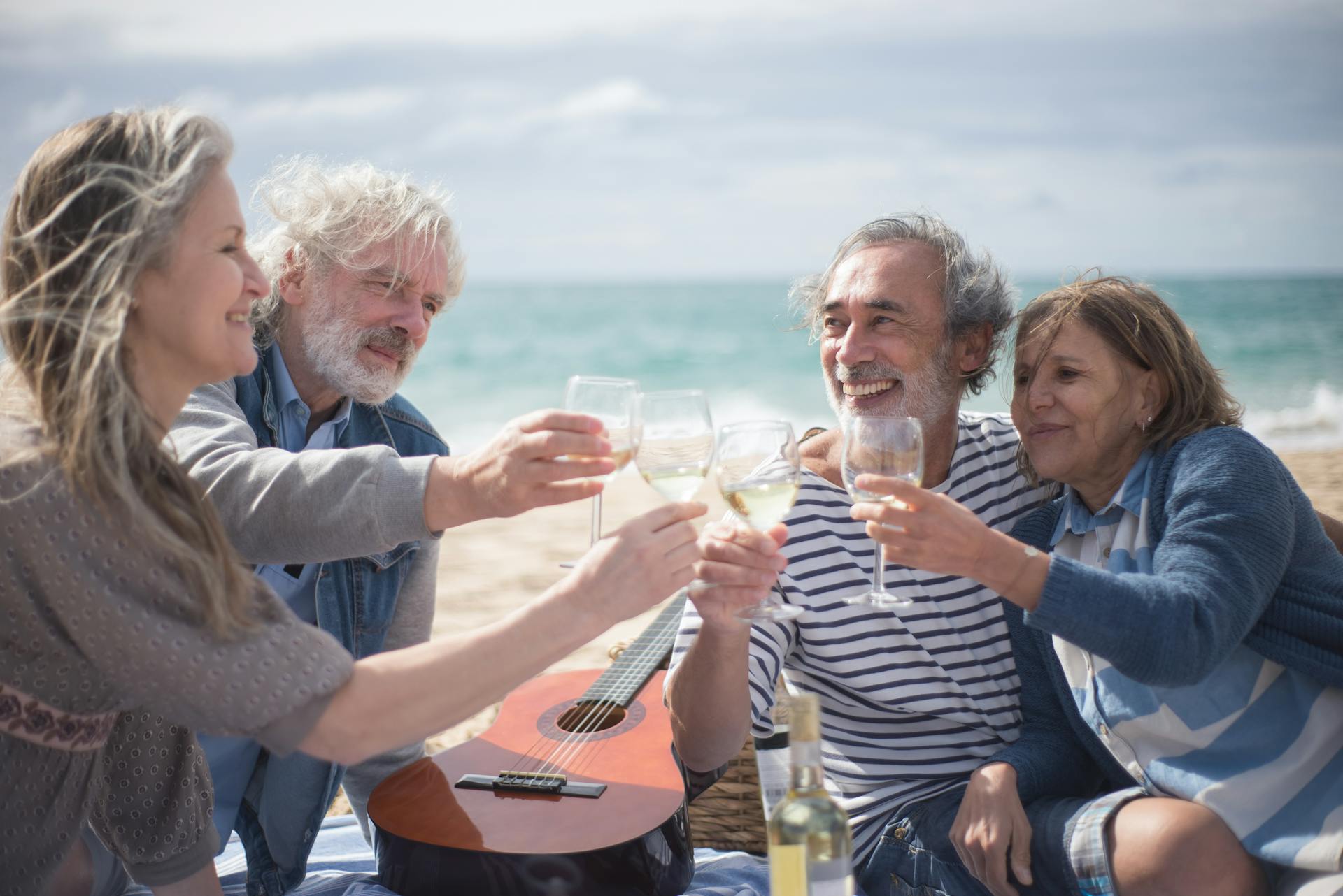 Gray-haired people toasting wine glasses at the beach | Source: Pexels