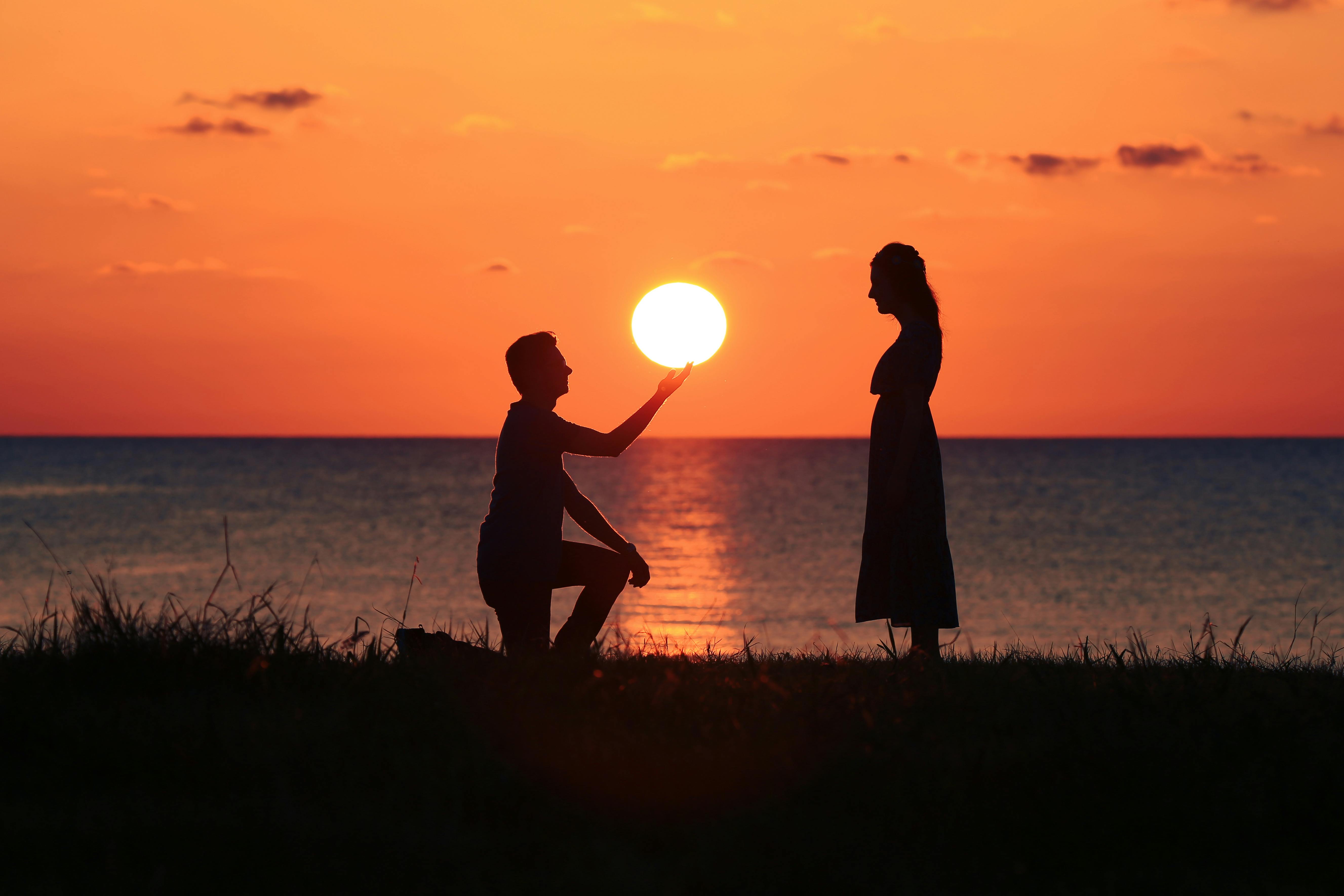 Silhouette of man kneeling before a woman at sunset | Source: Pexels