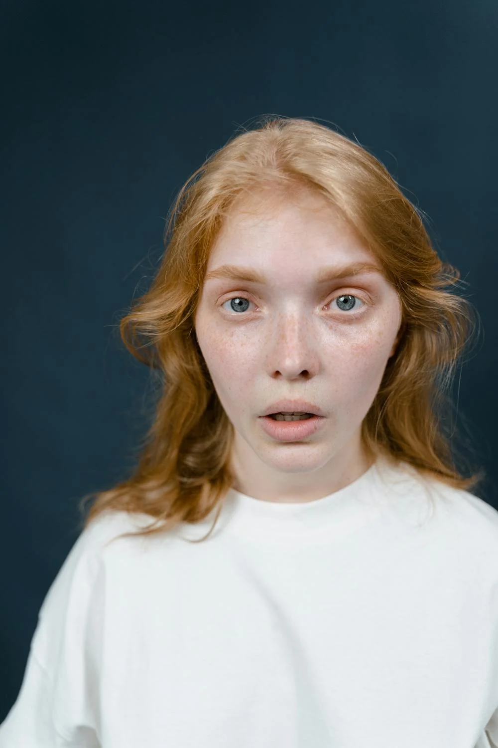 A shocked woman looking into the camera ⏐ Source: Pexels