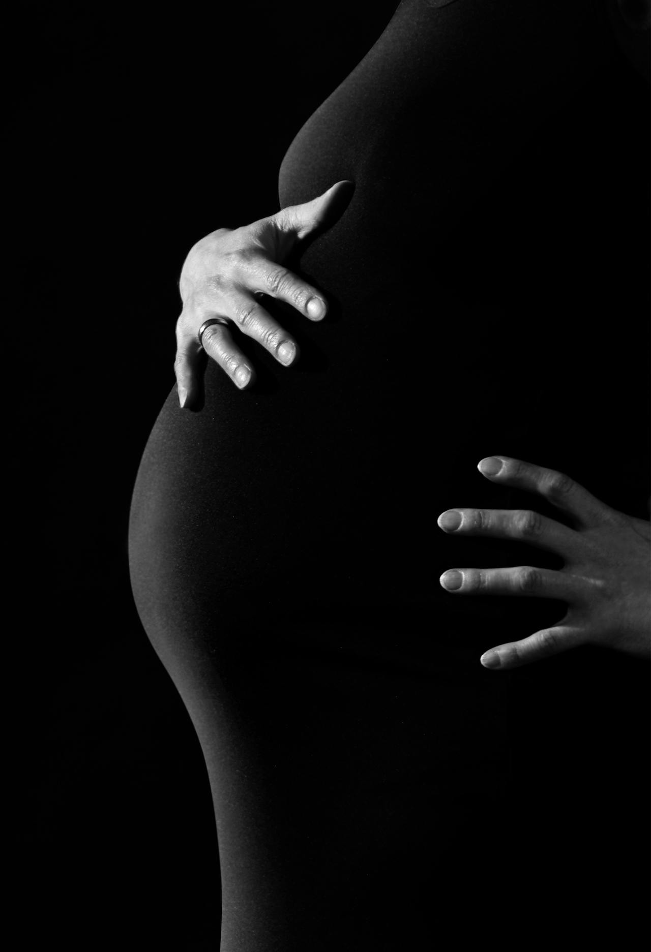 Photo monochrome recadrée d'une femme enceinte | Source : Pexels