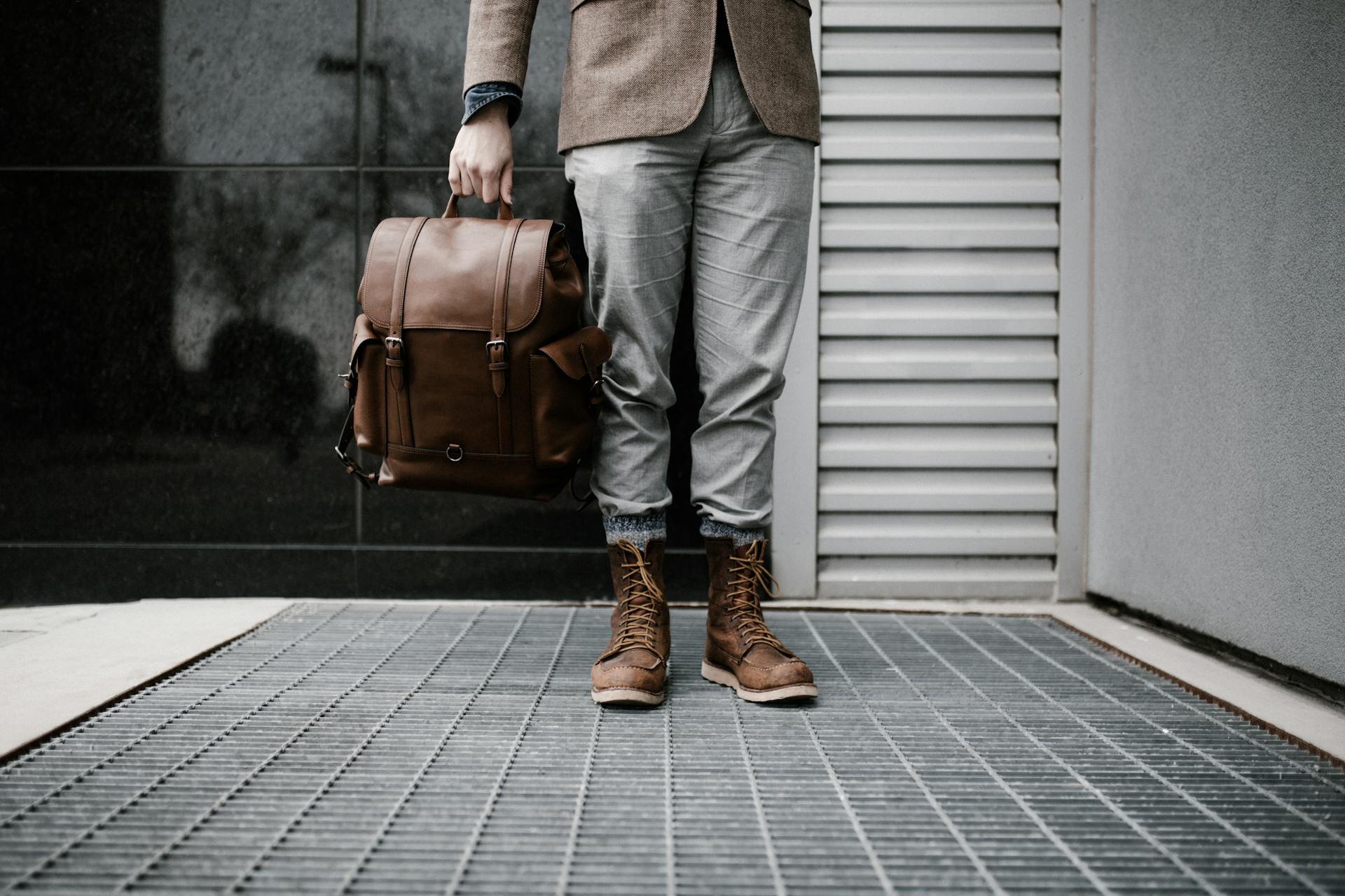 A man holding a brown leather bag | Source: Pexels