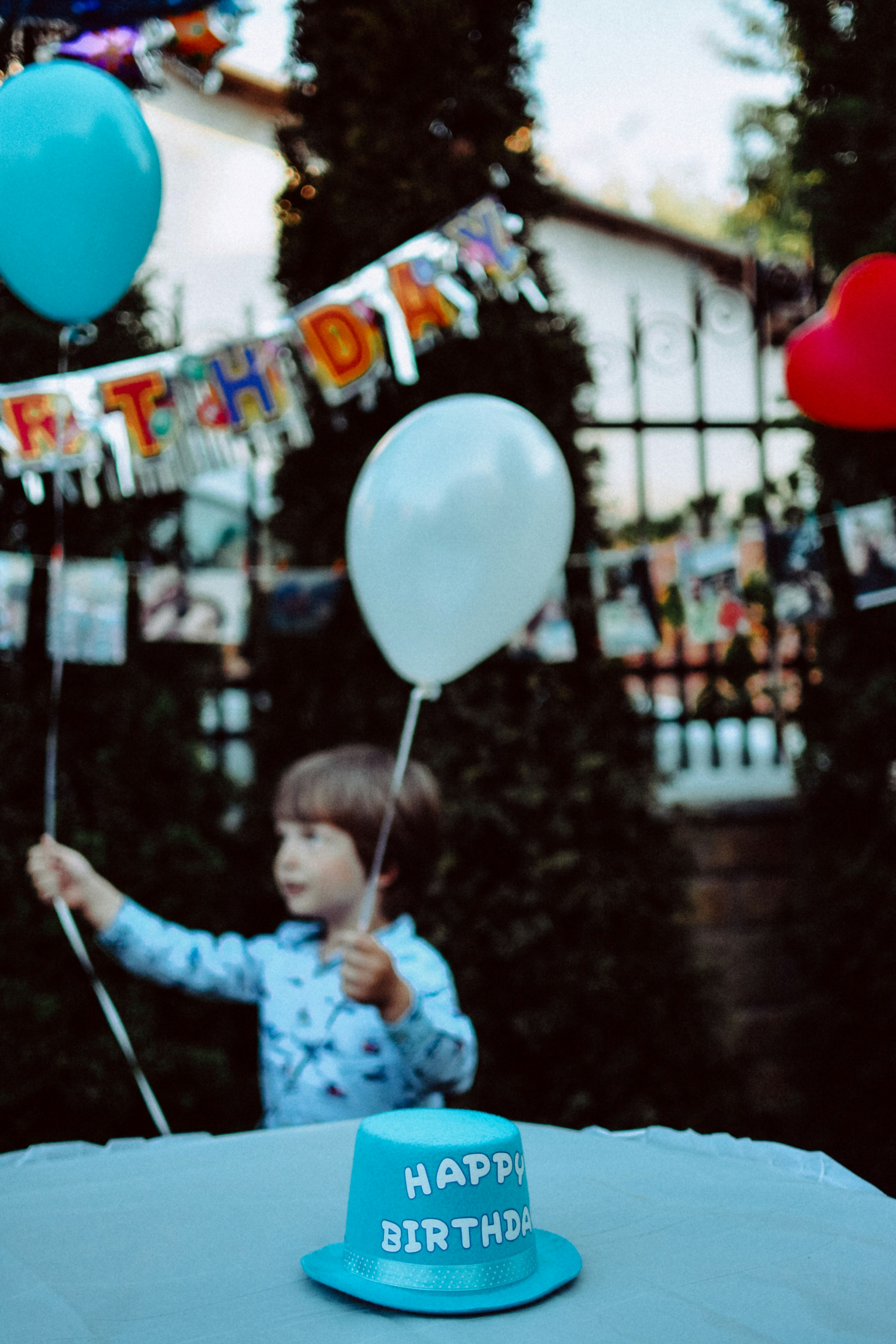 A little boy holding balloons at a birthday party | Source: Unsplash
