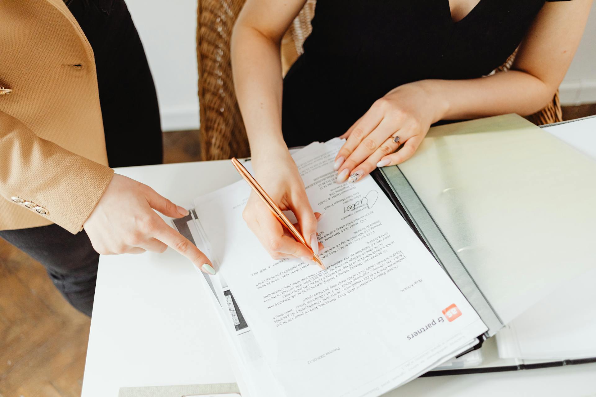 A woman signing documents | Source: Pexels