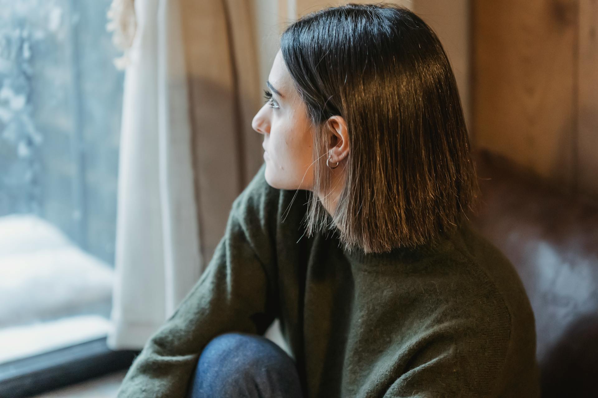 A thoughtful woman sitting by the window | Source: Pexels