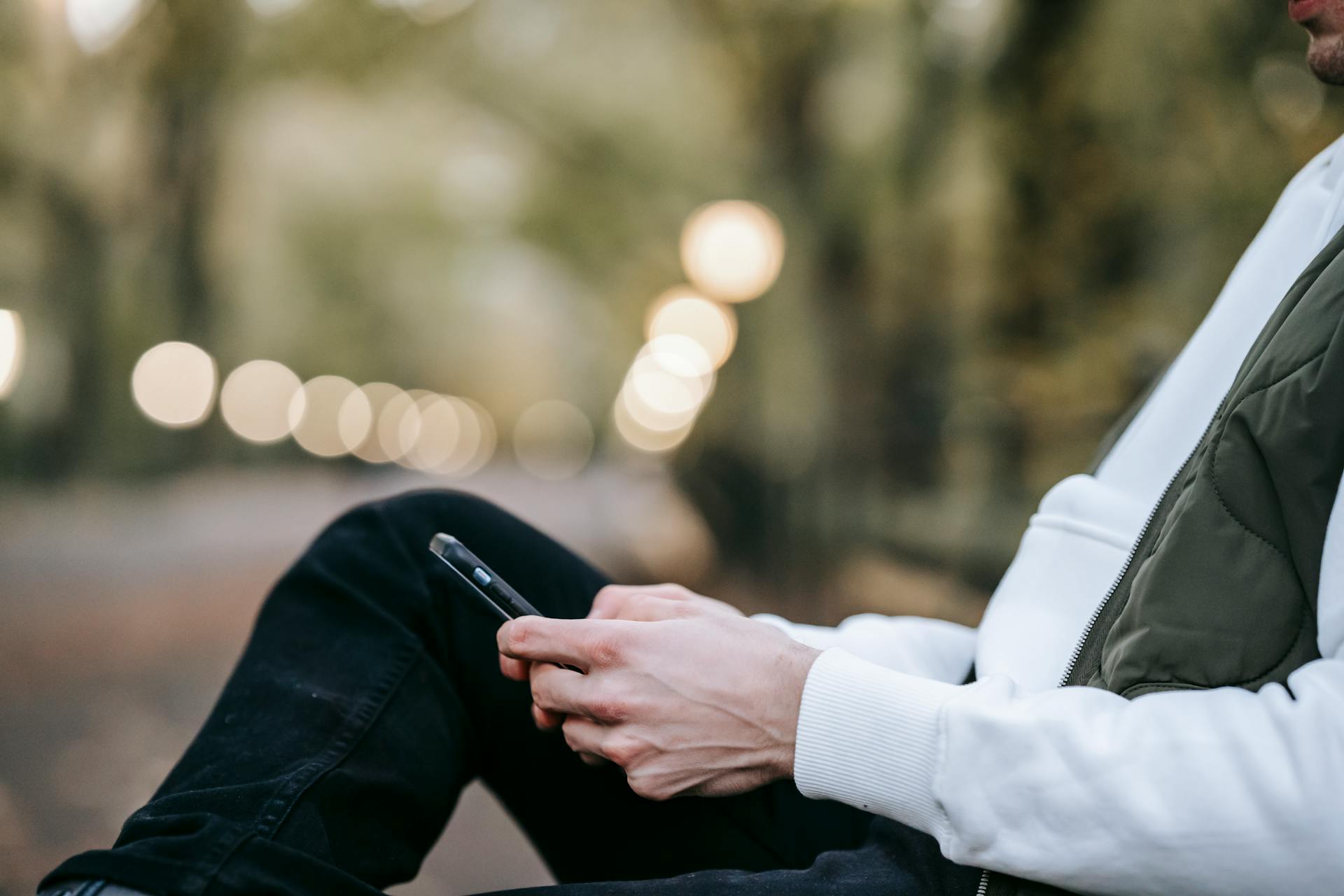 A man sitting on a bench and holding a phone | Source: Pexels