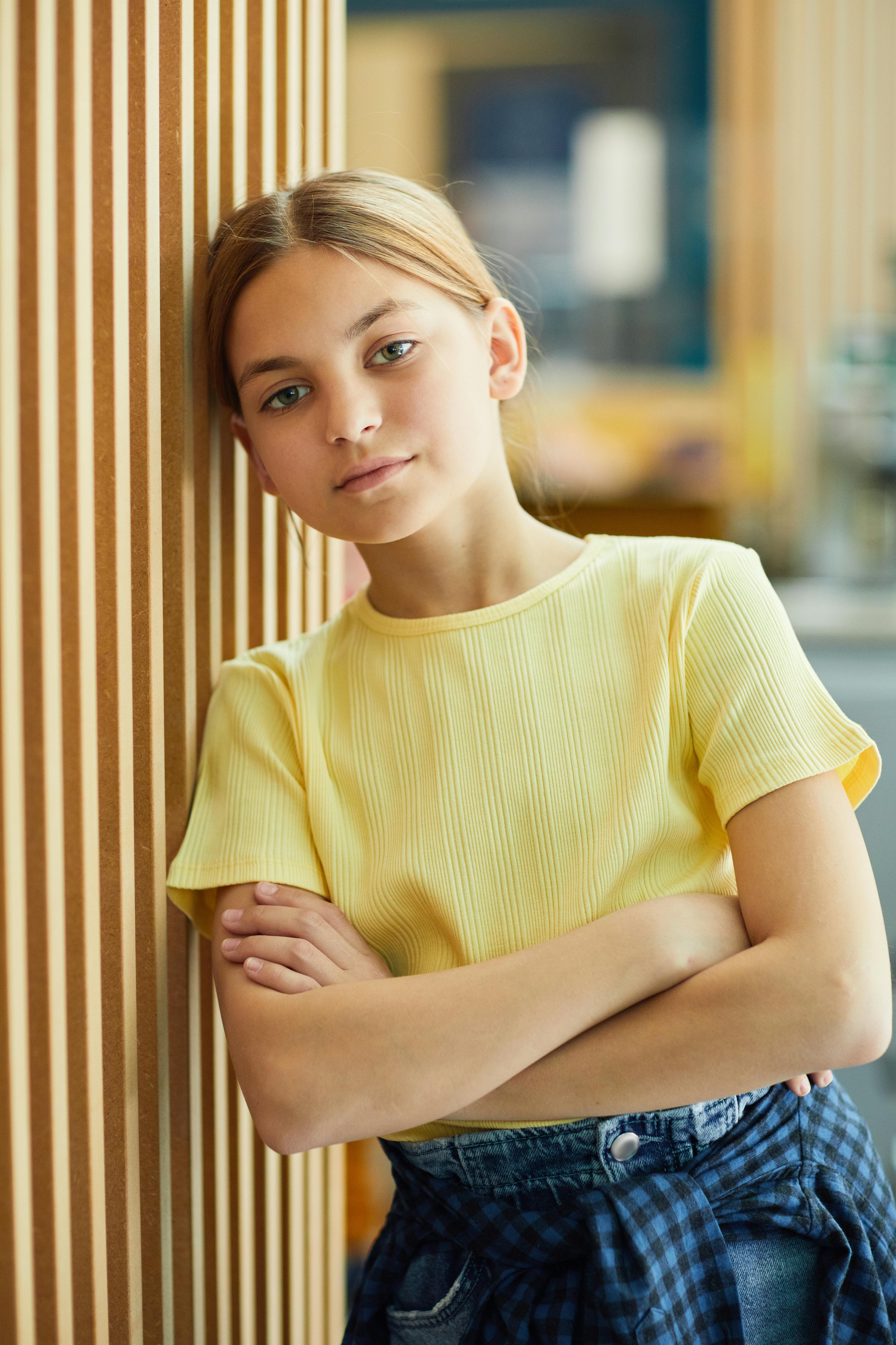 A serious girl leaning against a wall | Source: Pexels