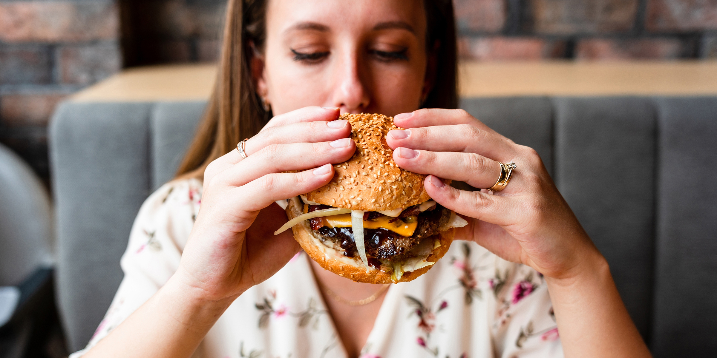 A woman eating a burger | Source: Shutterstock