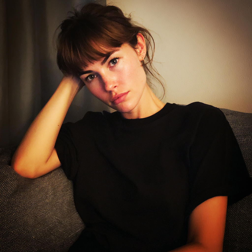 A pensive woman sitting on a couch | Source: Midjourney
