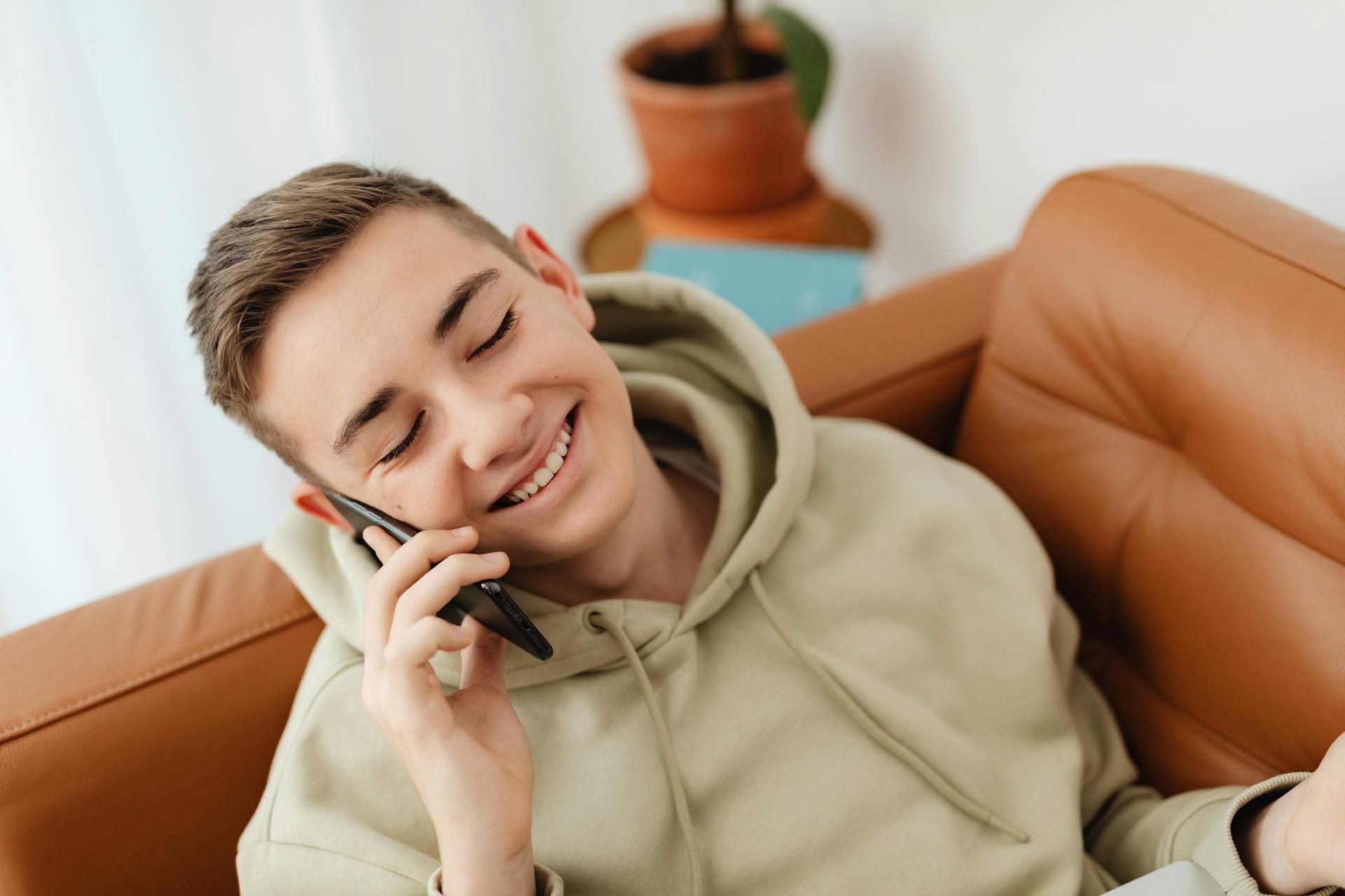A delighted teenage boy talking on the phone | Source: Pexels