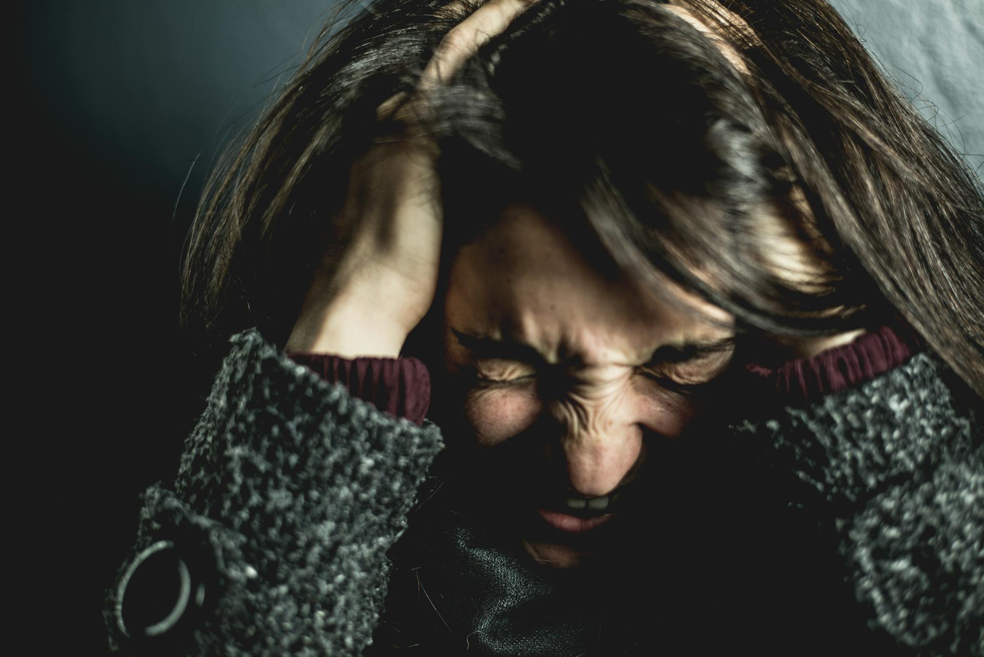 A very angry woman holding her head | Source: Pexels