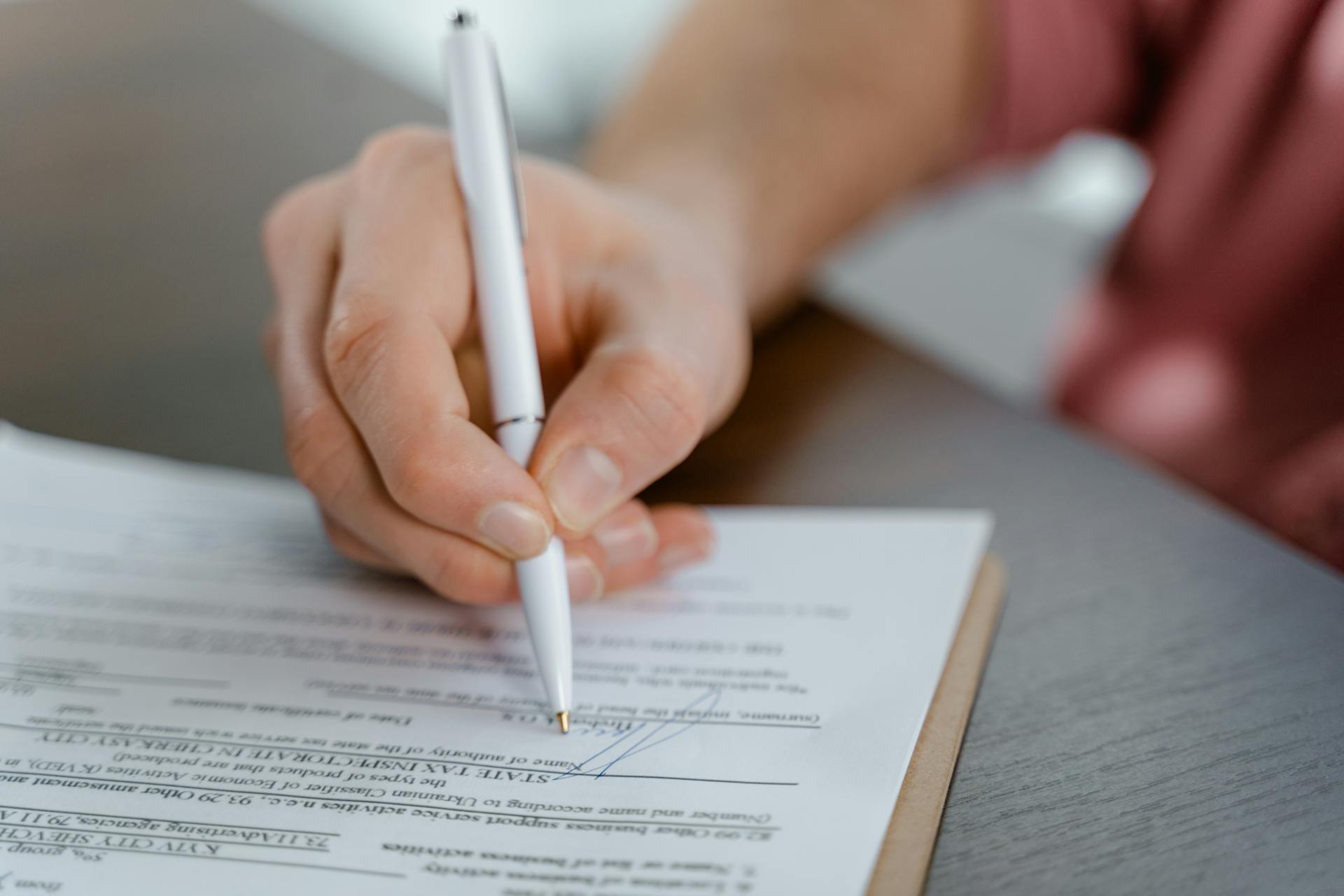 A person signing a paper | Source: Pexels