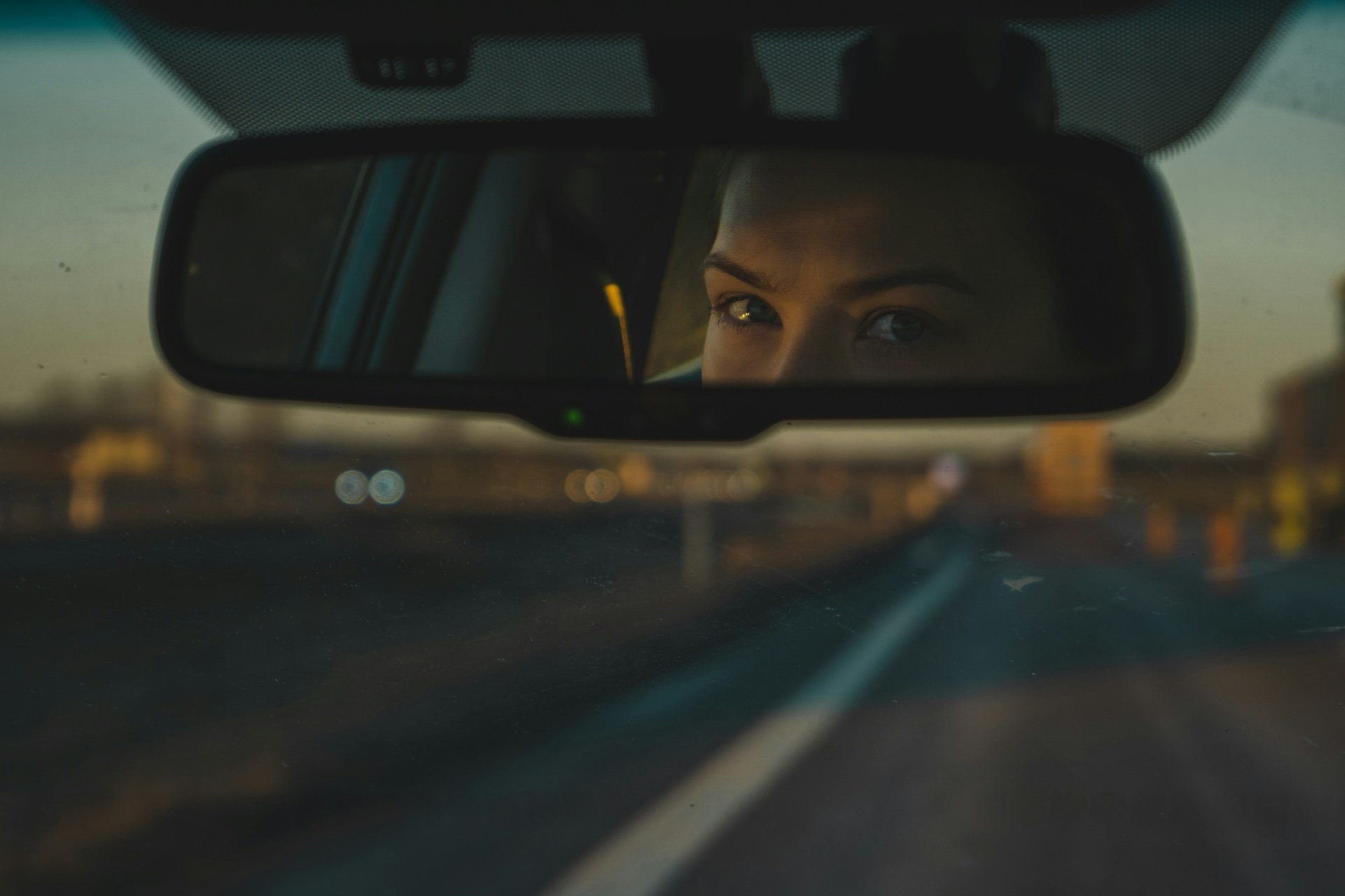 A woman looking in the rearview mirror | Source: Unsplash