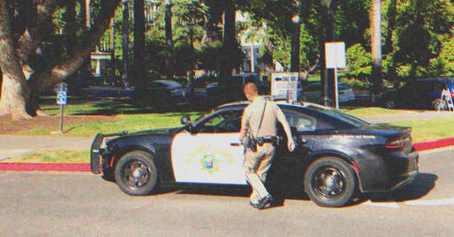 A police officer getting into a police car | Source: Shutterstock